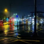 Ánh đèn thành phố lung linh phản chiếu trên đường ướt sau cơn mưa, tạo nên khung cảnh lãng mạn cho nhiếp ảnh