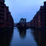 Ảnh phản chiếu ánh đèn thành phố trên sông vào buổi tối, minh họa khả năng chụp ảnh thiếu sáng mà không cần tripod của điện thoại.