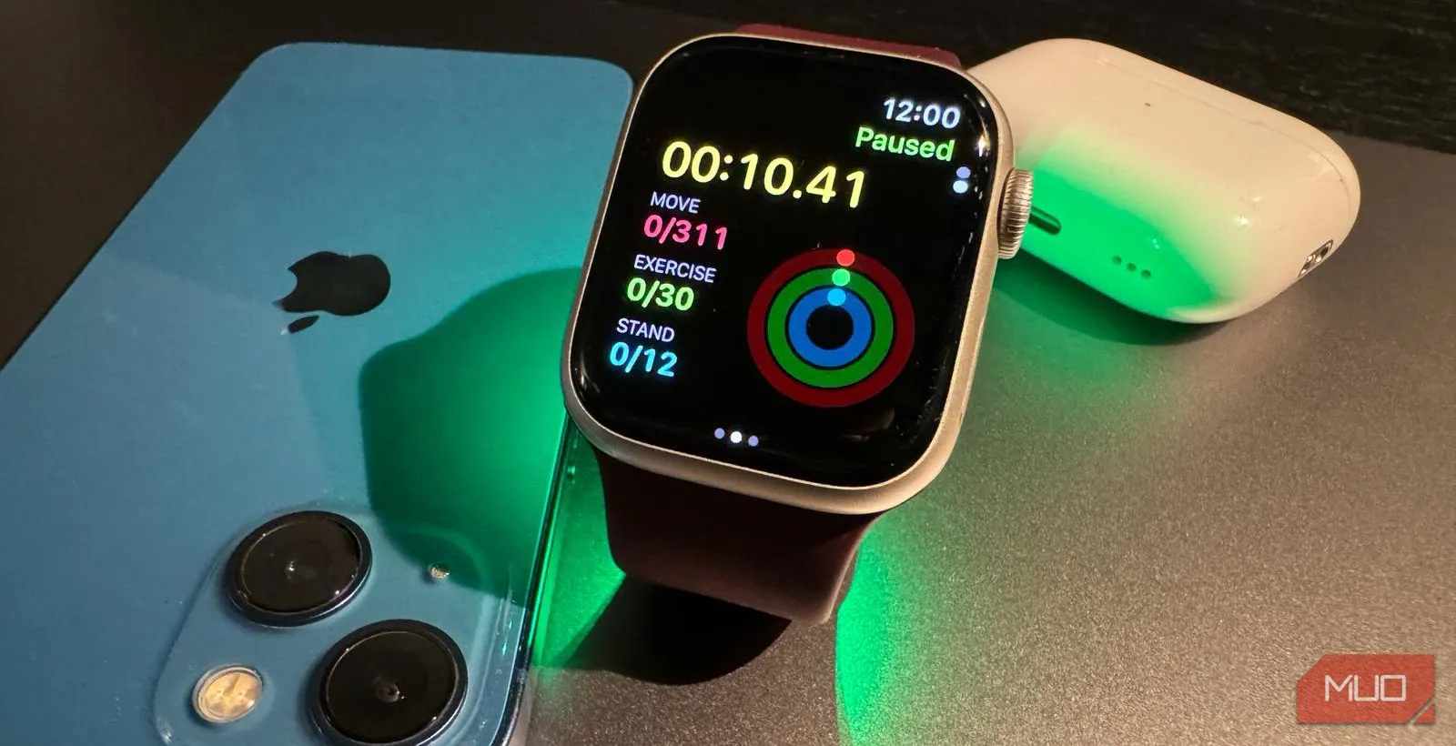 Apple Watch Series 9 đang chạy một buổi tập luyện, cùng với iPhone và AirPods Pro ở phía sau