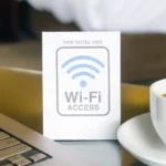 Biển báo Wi-Fi trong phòng khách sạn với laptop mở, tượng trưng cho việc kết nối internet chậm
