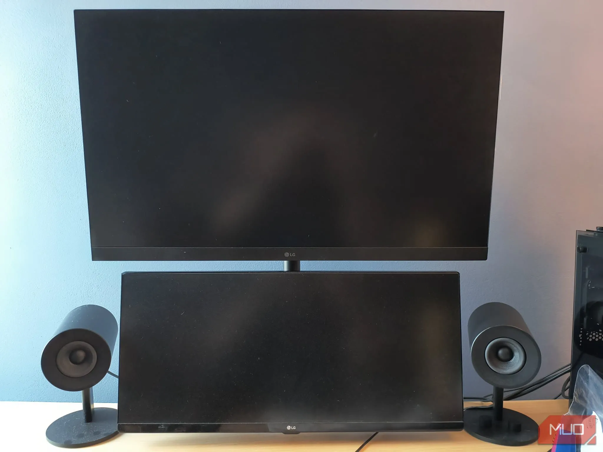 Cận cảnh bộ setup màn hình kép được gắn trên tay nâng dọc, hai loa đặt hai bên, giúp tối ưu không gian và cải thiện tư thế làm việc.