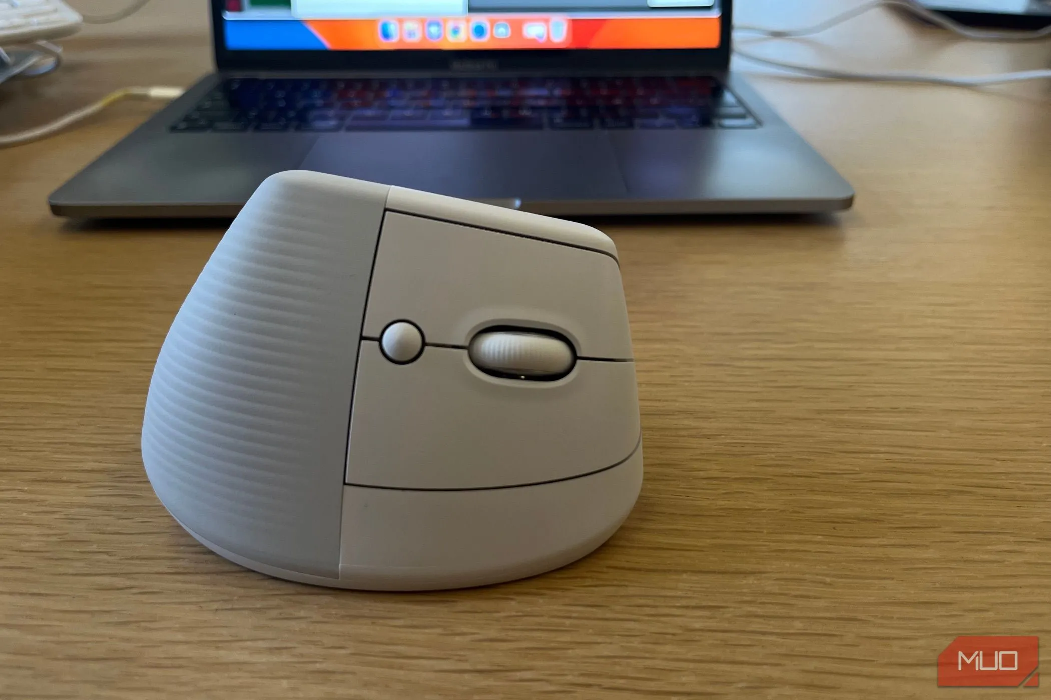 Chuột không dây Logitech Lift công thái học bên cạnh máy tính xách tay