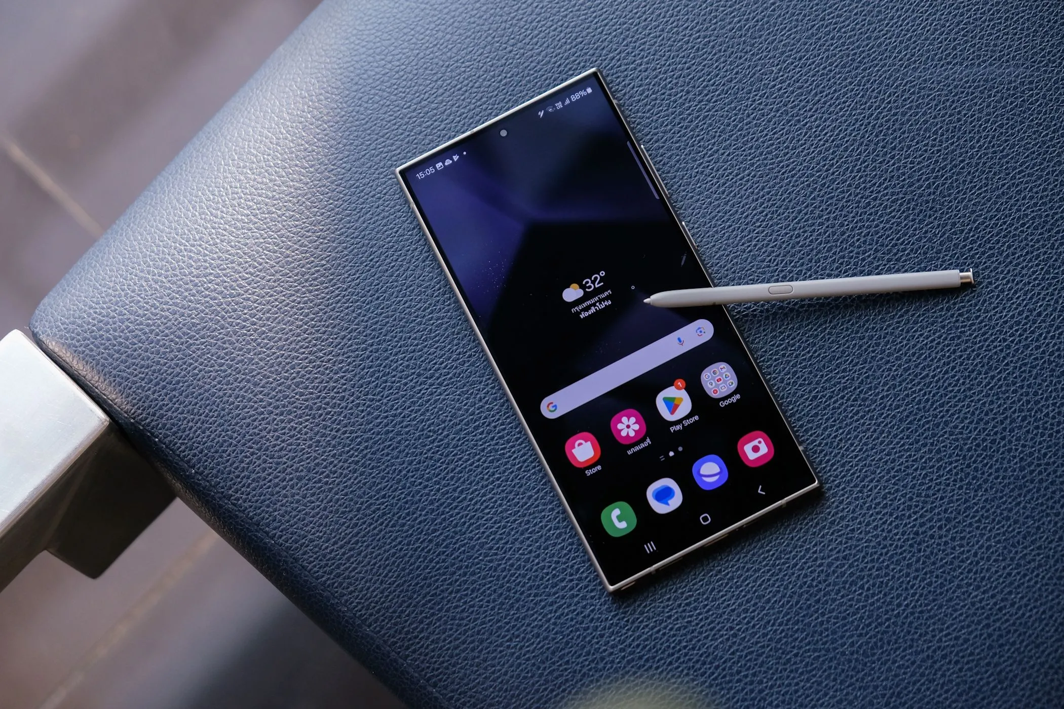 Điện thoại Samsung Galaxy S24 Ultra kèm bút S Pen đặt trên cạnh ghế