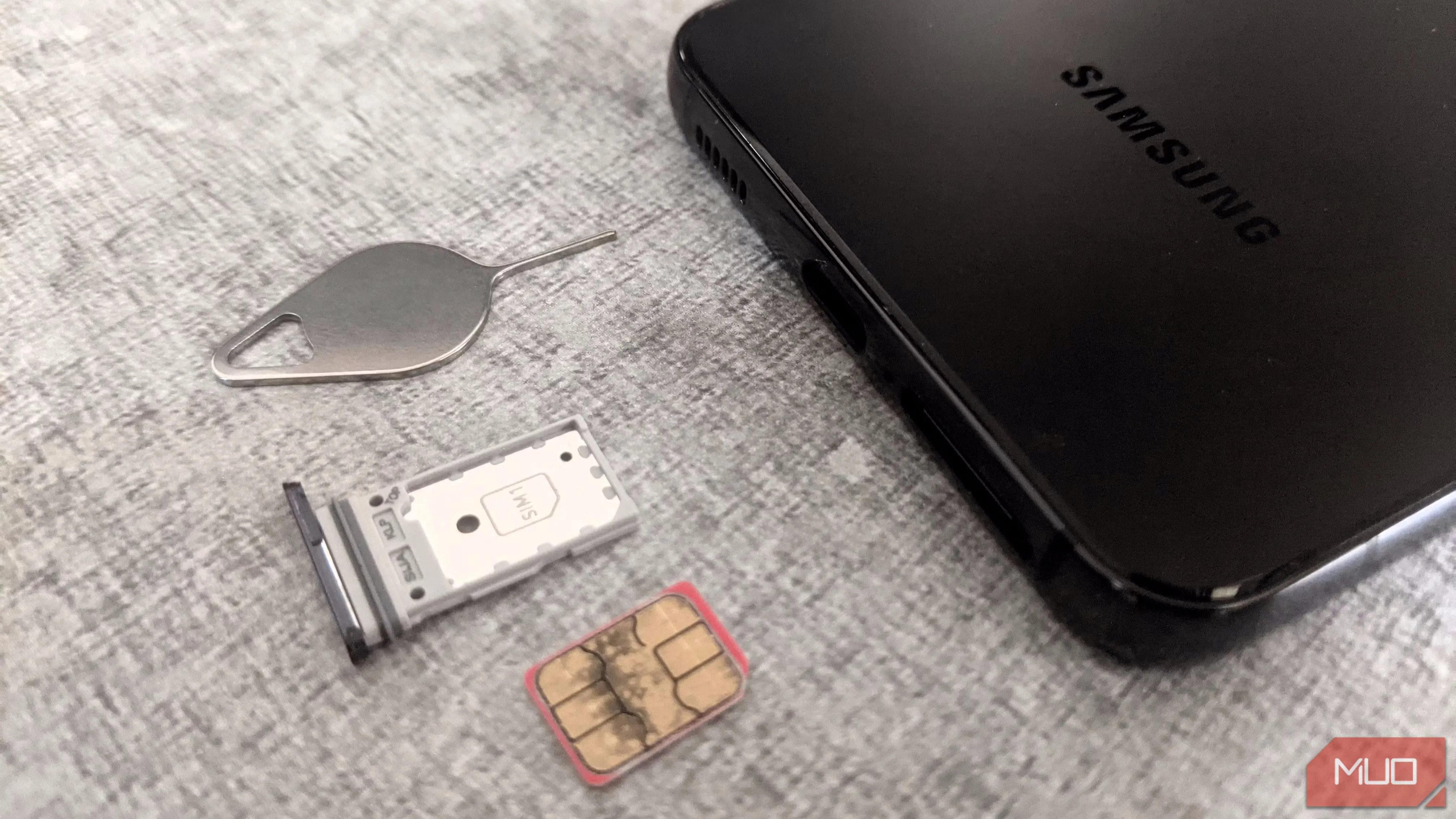 Điện thoại Samsung, khay SIM và dụng cụ lấy SIM, minh họa nguy cơ tấn công SIM-swapping.
