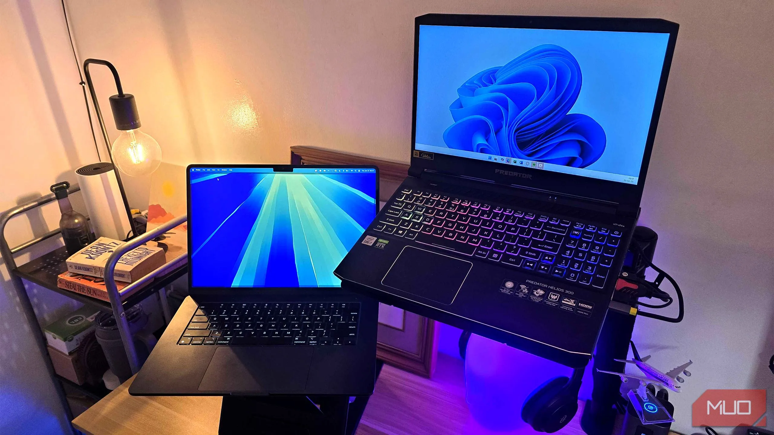 Hình ảnh laptop chạy Windows 11 và macOS thể hiện sự đa dạng của máy tính hiện đại và tốc độ khởi động nhanh từ ổ SSD.