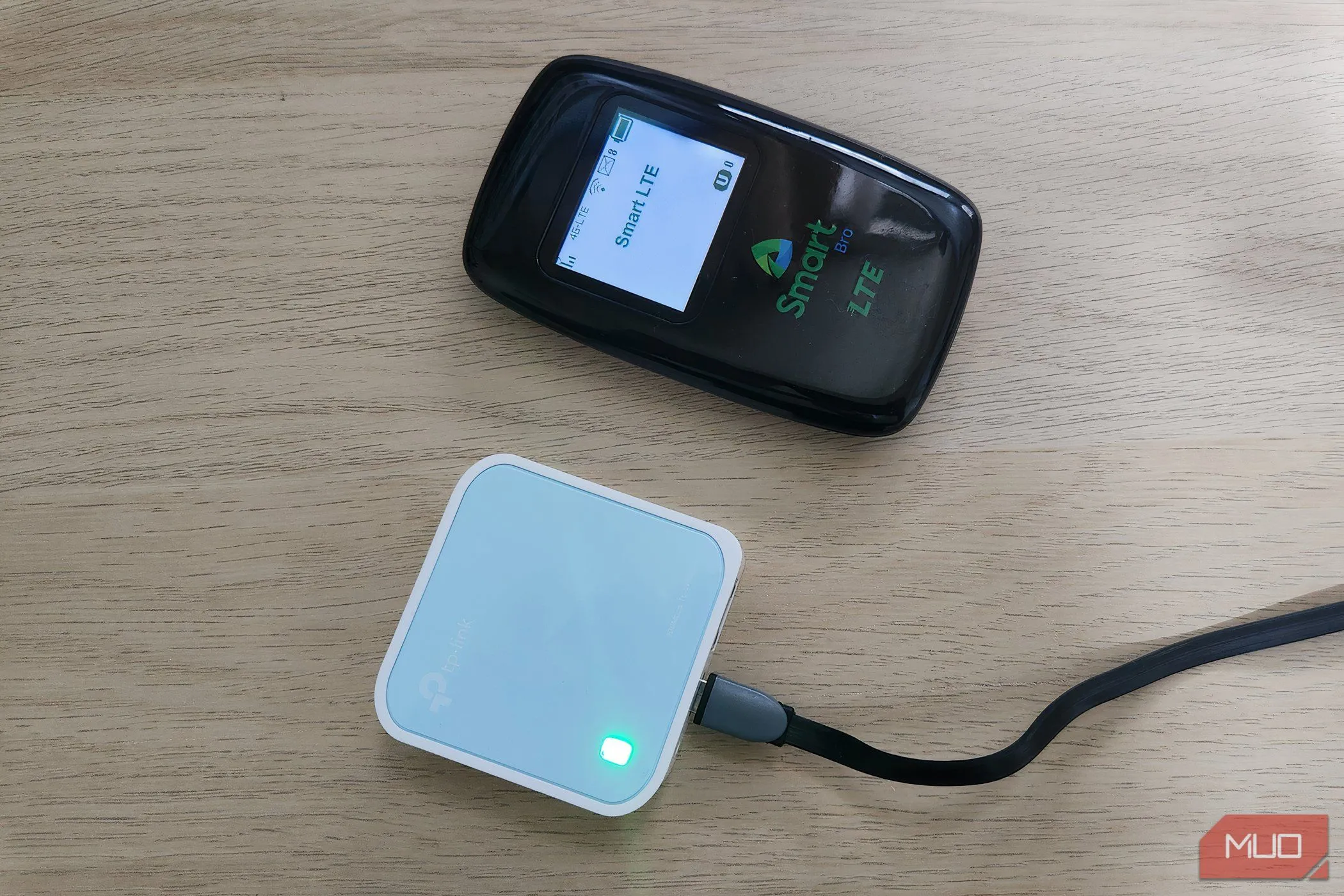 Hình ảnh một thiết bị phát Wi-Fi di động (MiFi) và một router du lịch nhỏ gọn trên bàn làm việc, minh họa giải pháp kết nối internet an toàn khi di chuyển