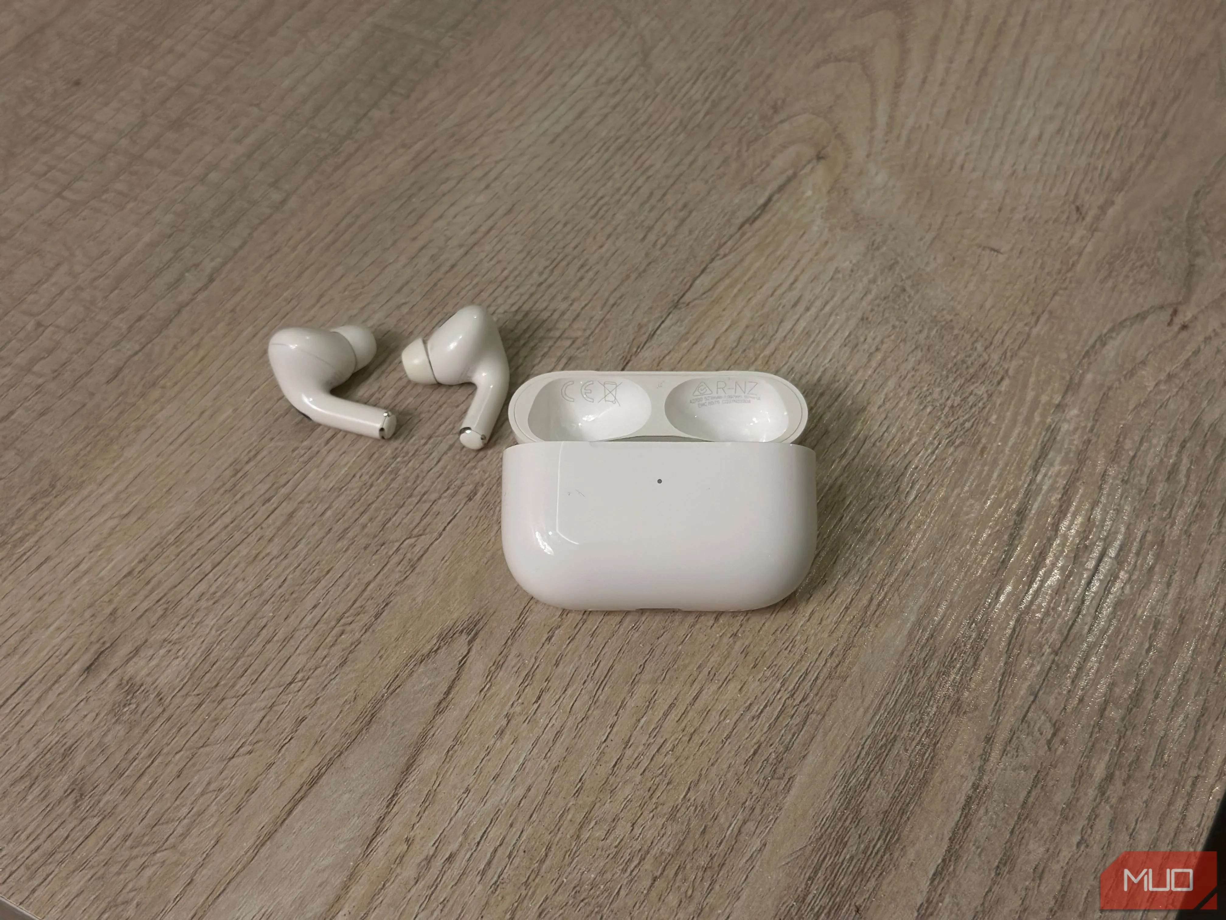 Hộp sạc AirPods và tai nghe AirPods đang mở để tìm số model, serial