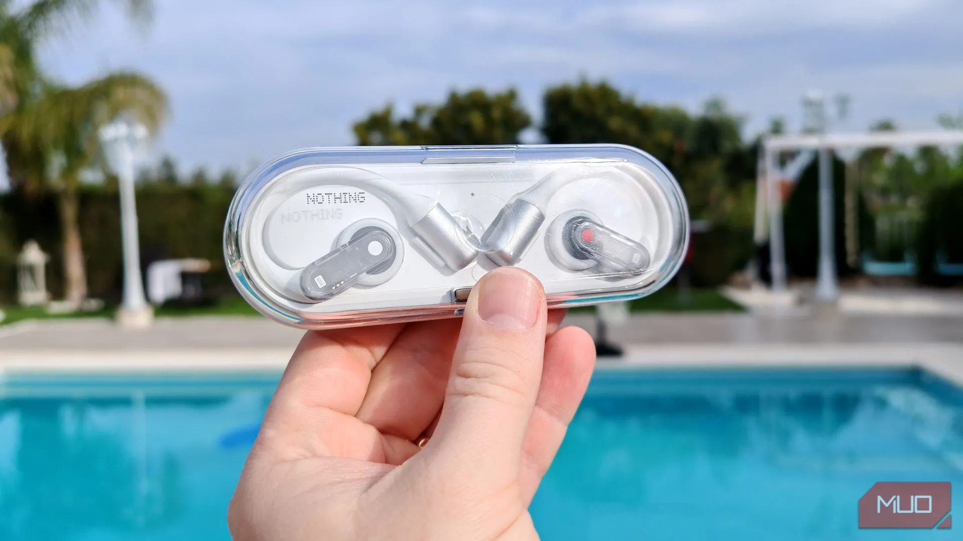 Hộp sạc Nothing Ear (open) với thiết kế trong suốt đặc trưng được cầm trên tay ngoài trời