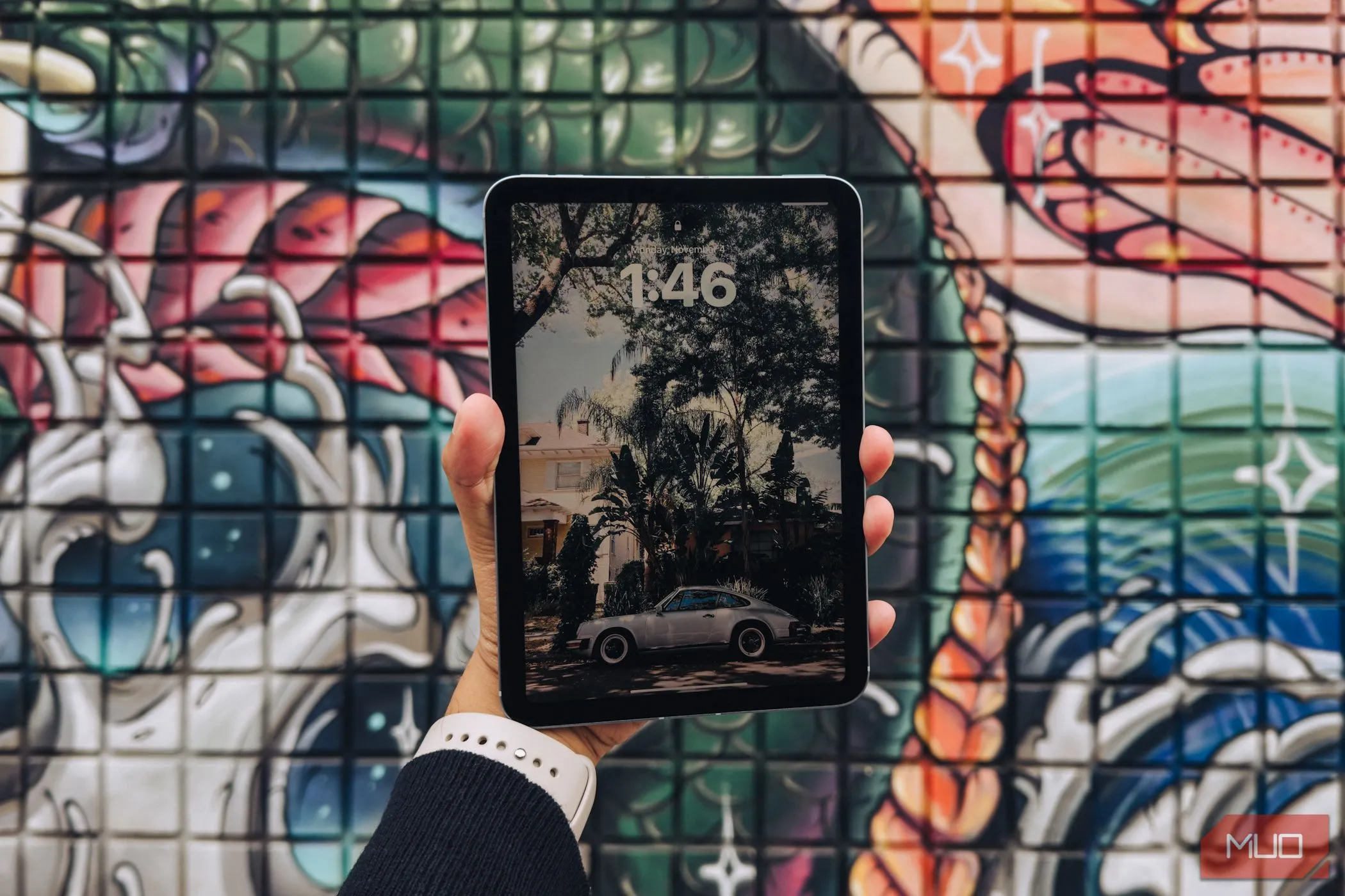 iPad Mini (A17 Pro) cầm trên tay với phông nền graffiti (mặt màn hình)