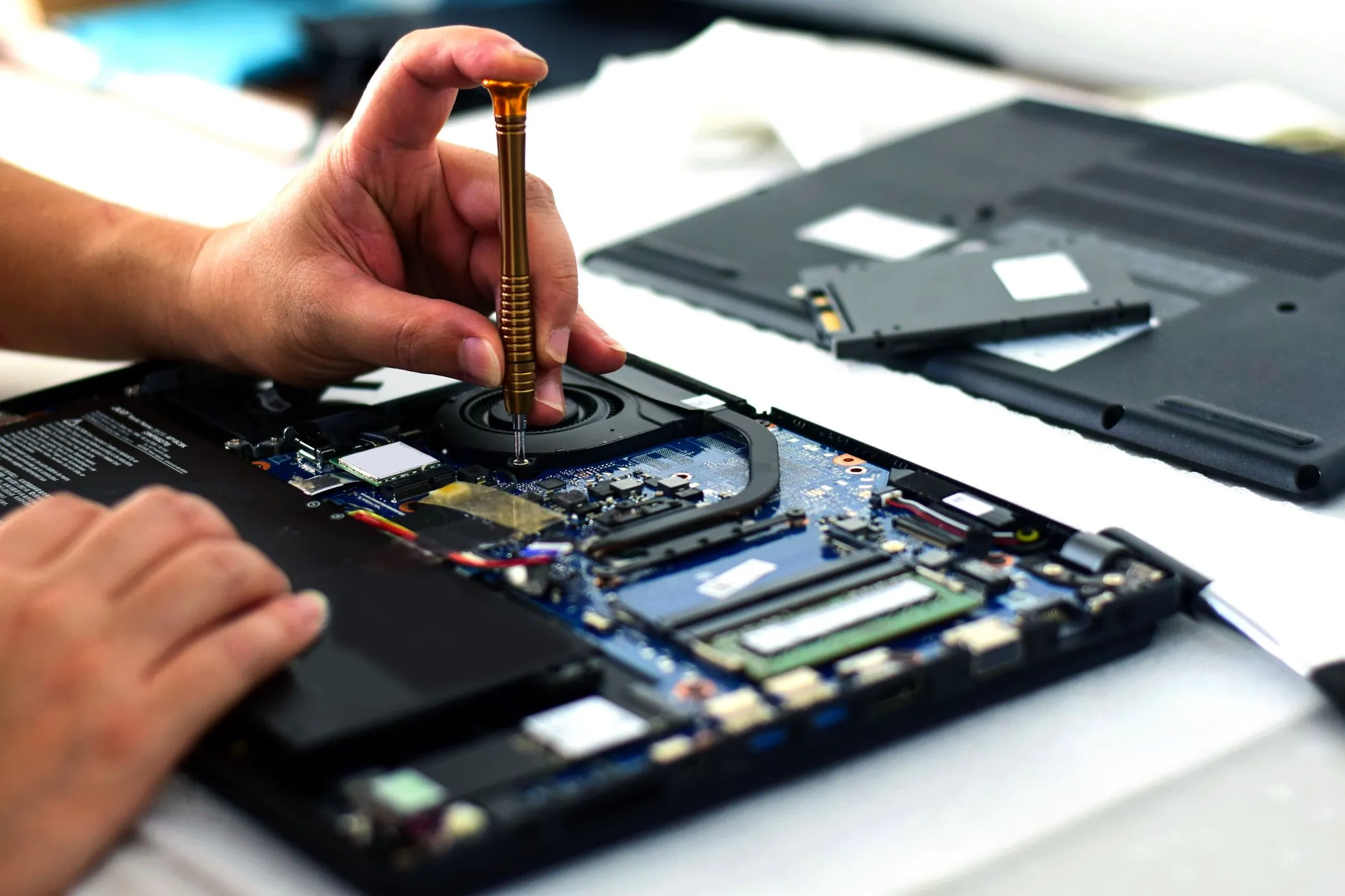 Kỹ thuật viên đang sửa chữa bo mạch chủ laptop, minh họa sự phức tạp khi sửa các mẫu mỏng nhẹ