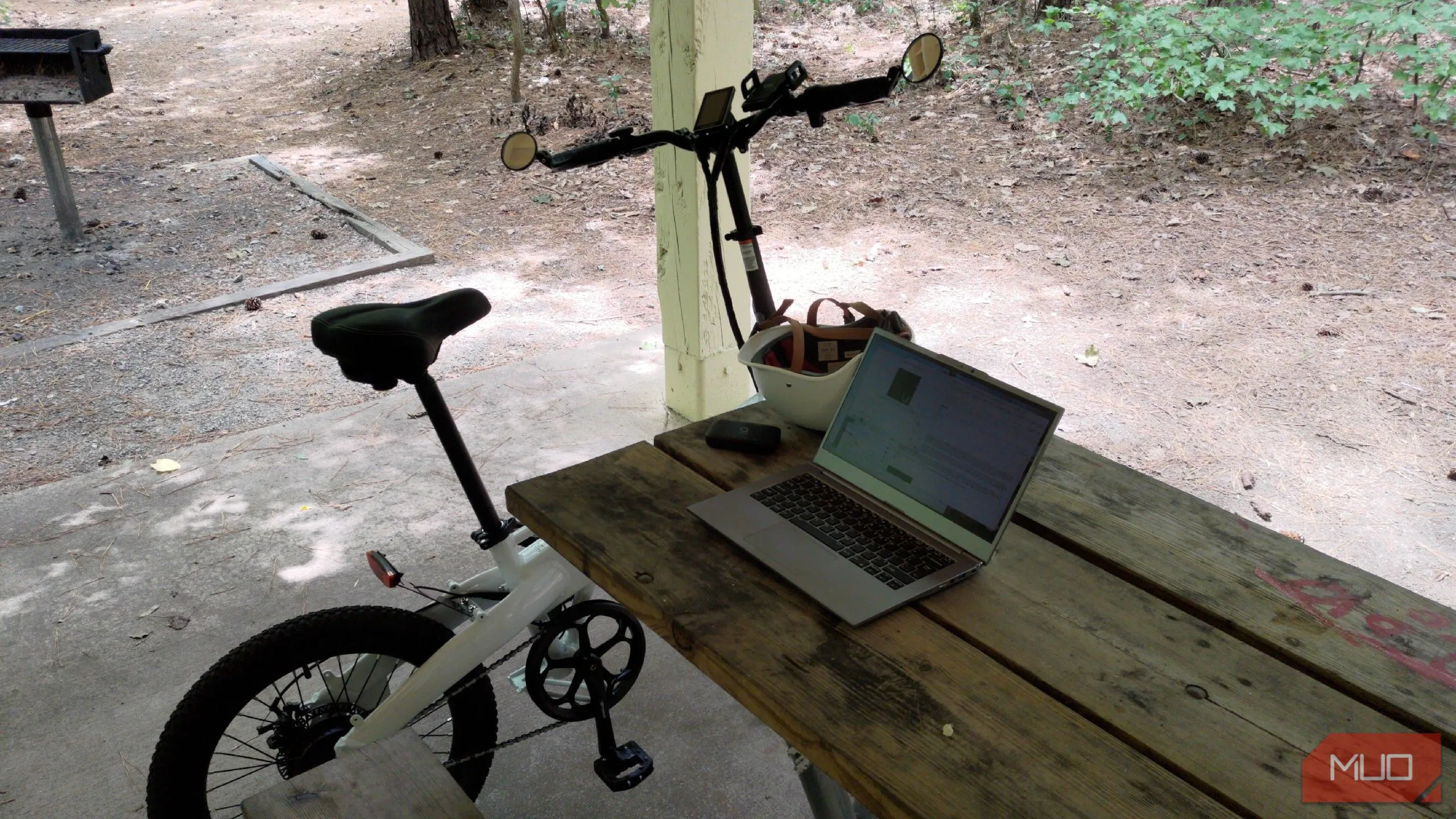 Laptop Clevo màu đen đặt cạnh xe đạp điện Lectric ebike, cả hai đều có thiết kế tối giản