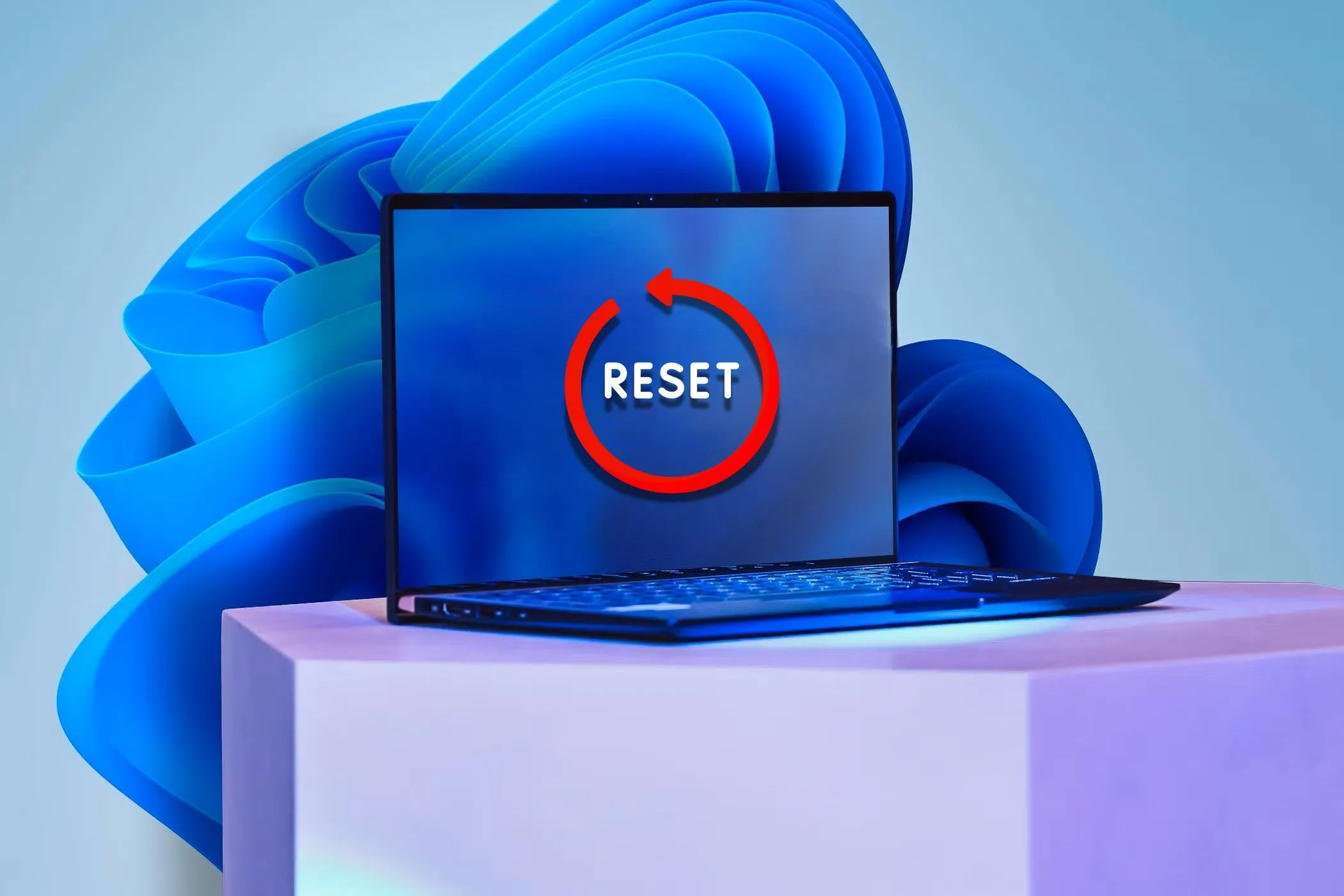 Laptop với nhãn dán &quot;Reset&quot; trên màn hình và hình nền Windows 11