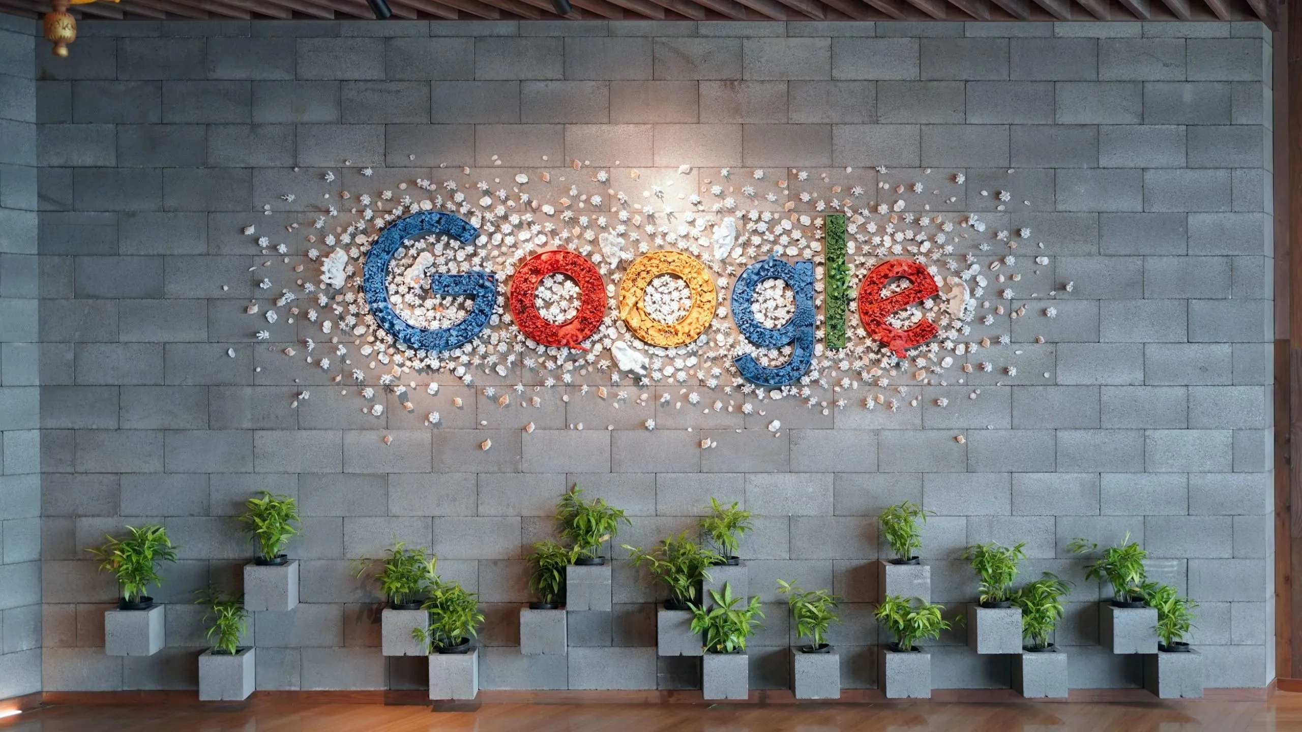 Logo Google trên tường văn phòng, thể hiện sự tích hợp sâu rộng và đồng bộ hóa liền mạch của Chromebook với hệ sinh thái Google