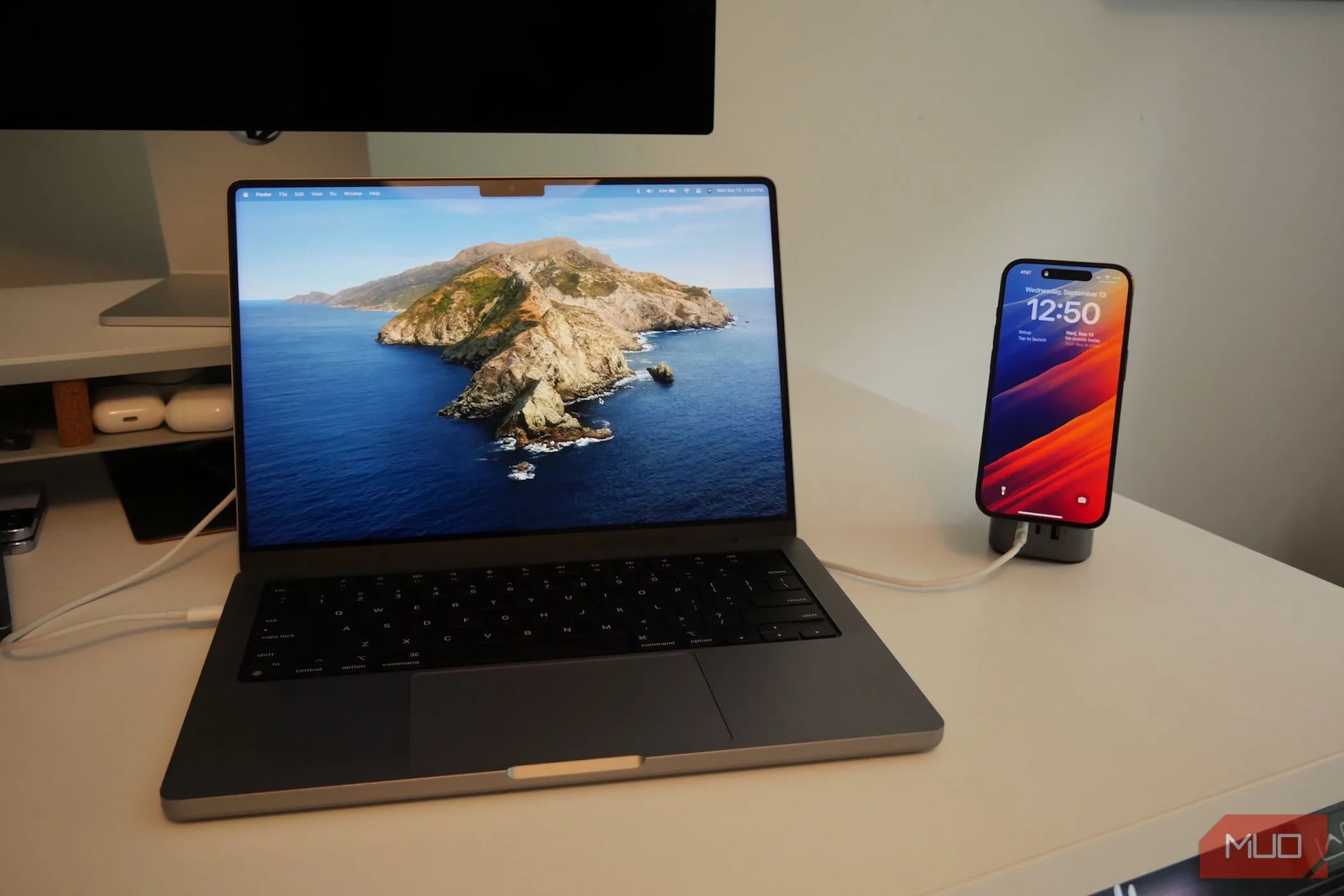 MacBook Pro và iPhone đang sạc, thể hiện sự kết nối giữa hai thiết bị