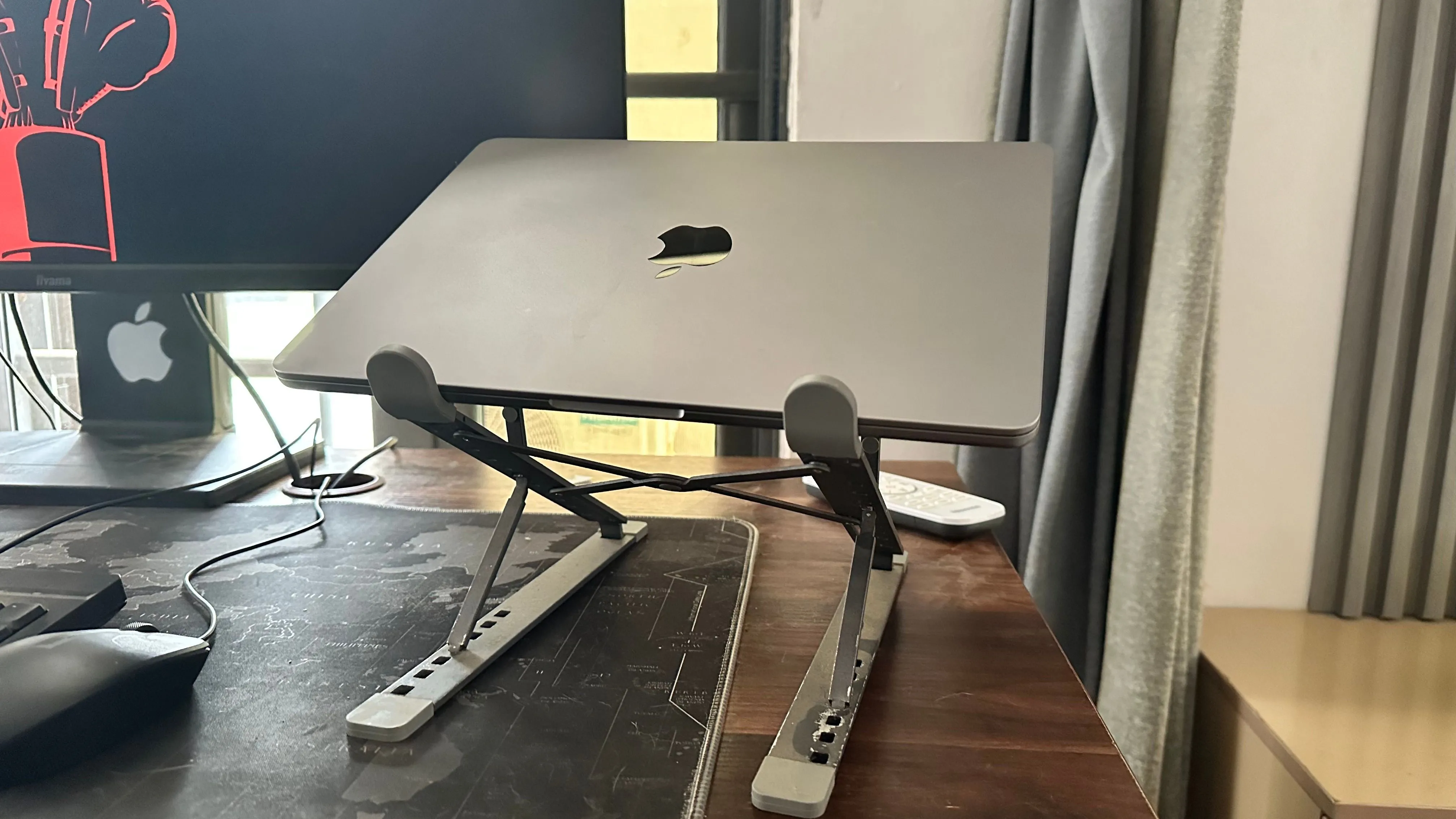 MacBook trên đế laptop cạnh màn hình