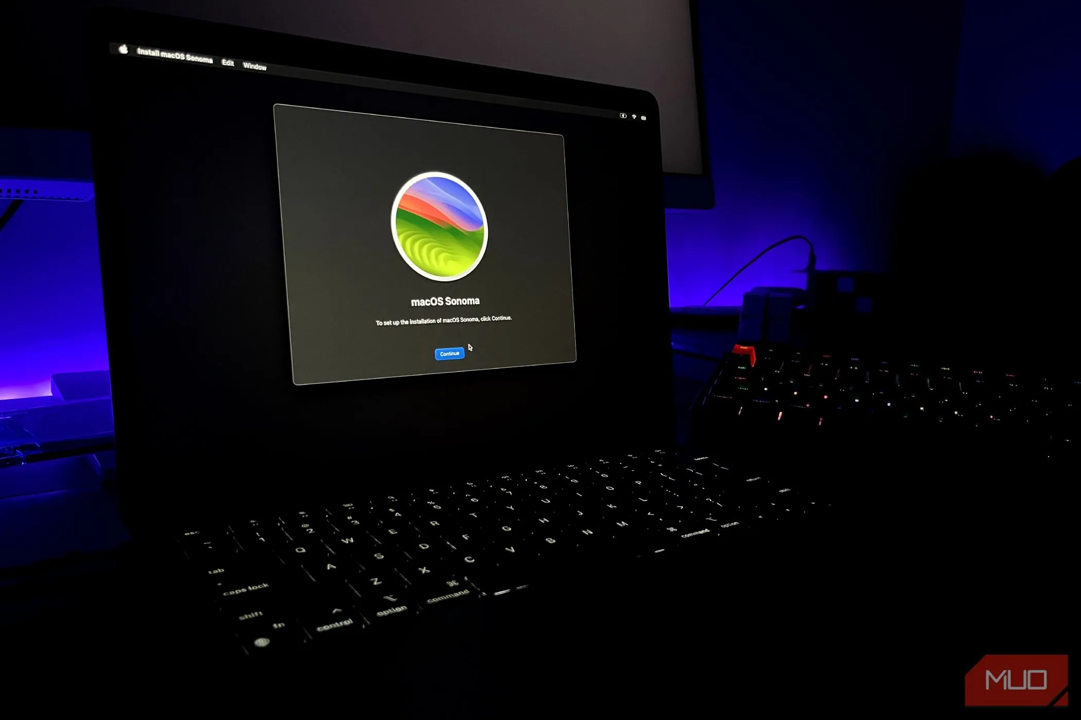 macOS Sonoma installer đang mở trên MacBook Air với bàn phím ở hậu cảnh