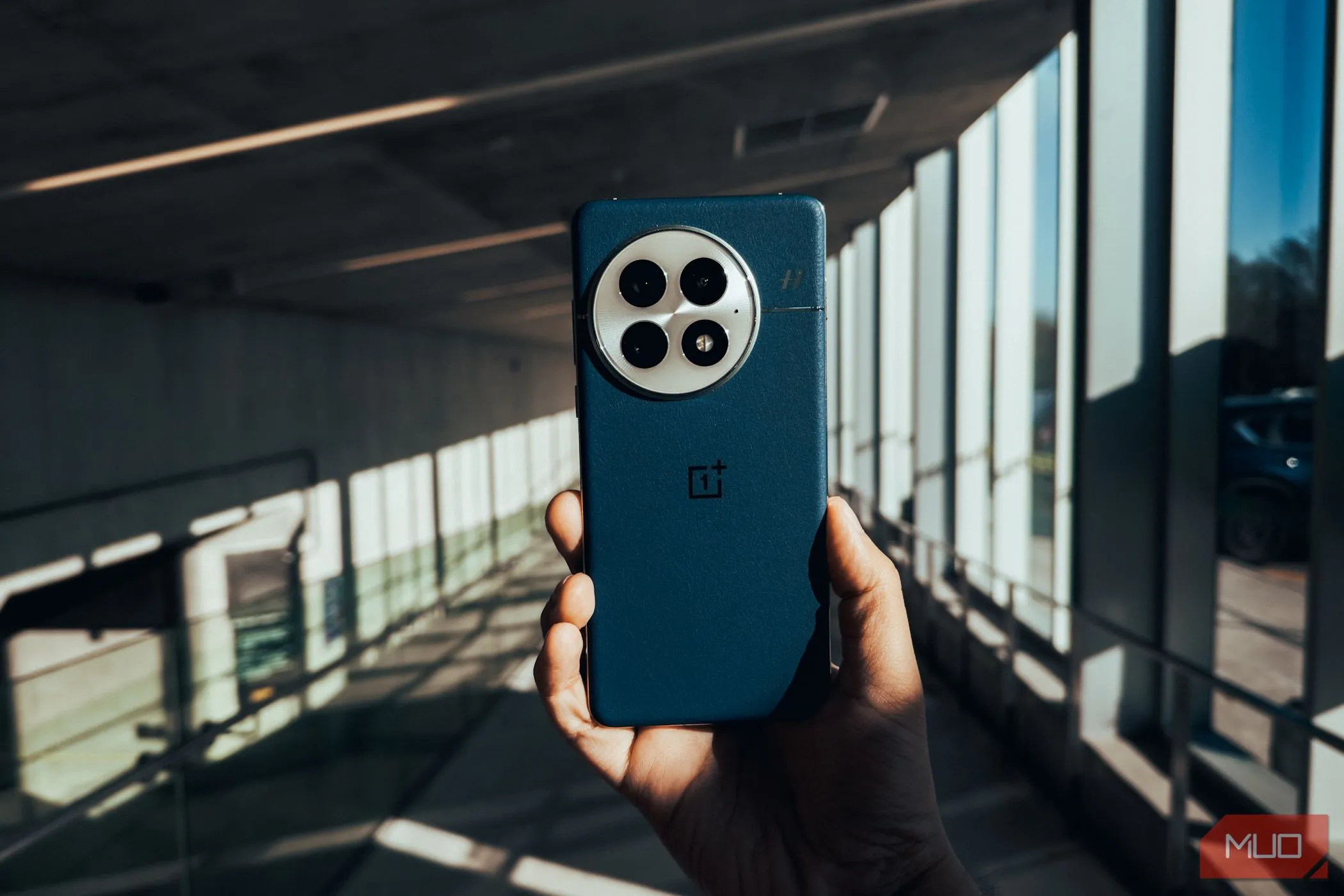 Mặt lưng của OnePlus 13 với khung cảnh đô thị phía sau, thể hiện sự mạnh mẽ và hiện đại