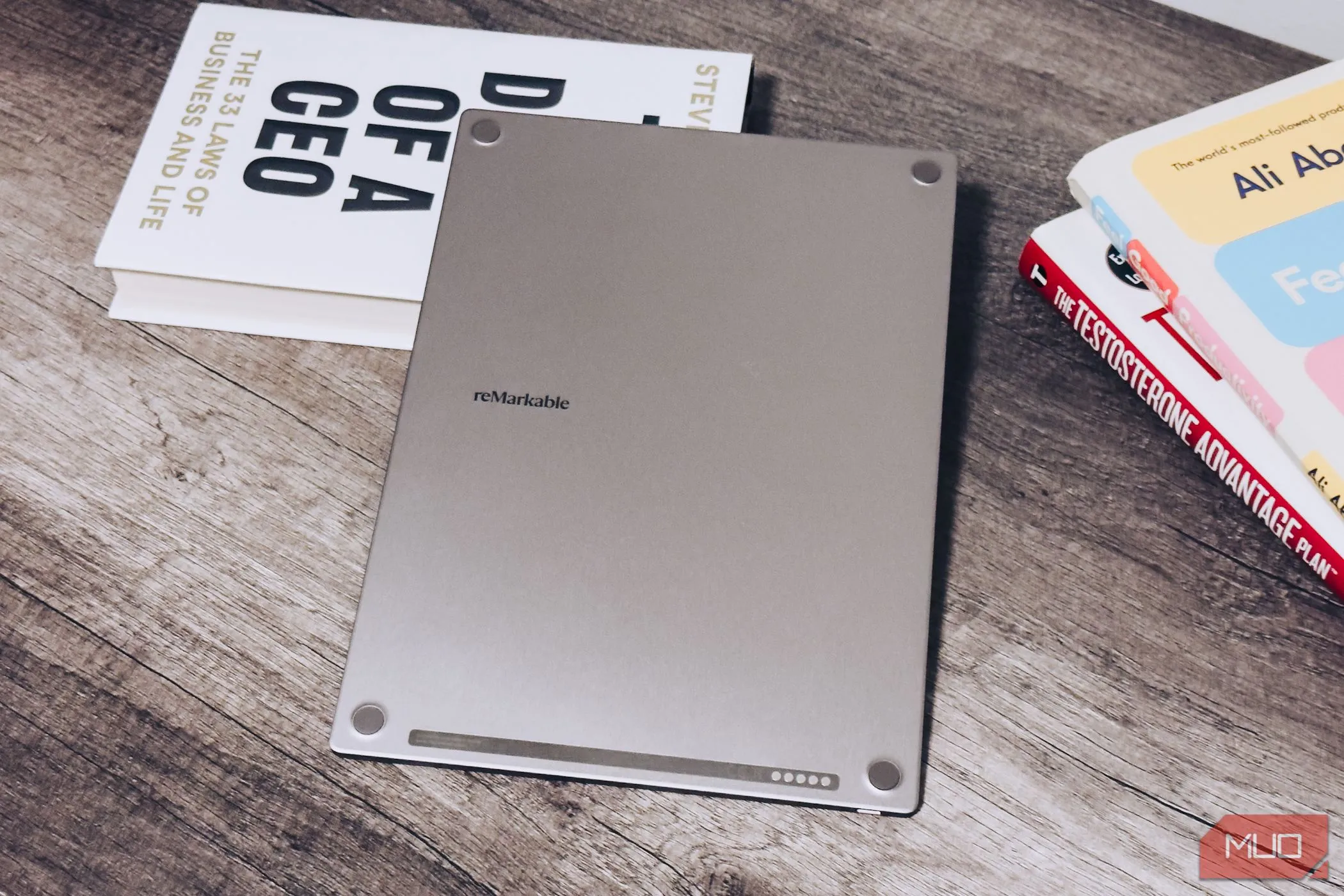 Mặt lưng reMarkable Paper Pro đặt trên bàn gỗ cạnh những cuốn sách
