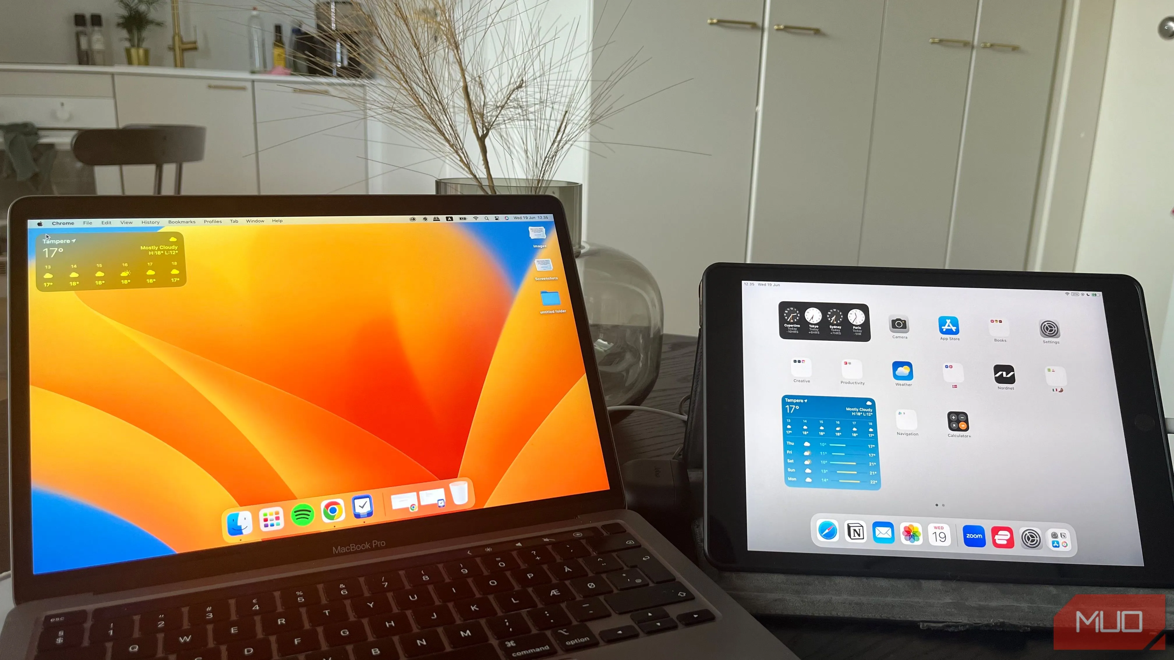 Máy tính MacBook và iPad đặt cạnh nhau trên bàn làm việc gọn gàng