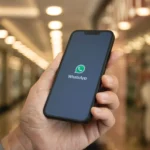 Một bàn tay đang cầm điện thoại thông minh hiển thị logo WhatsApp và tính năng phiên âm tin nhắn thoại