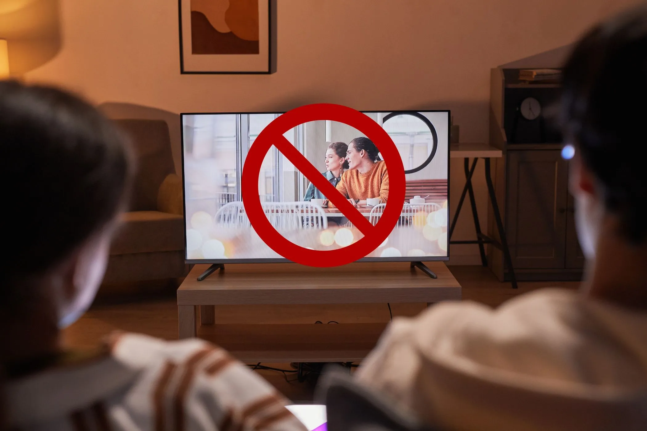 Một cặp đôi đang xem TV nhưng màn hình bị gạch chéo thể hiện việc không nên sử dụng thiết bị khác khi test tốc độ mạng