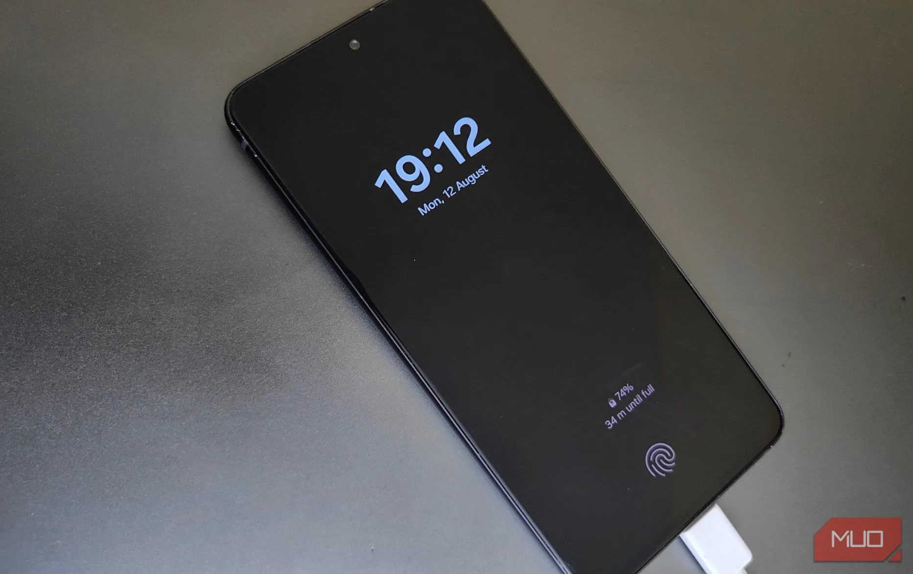 Một chiếc điện thoại Samsung đang sạc trên bàn làm việc