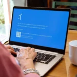 Một màn hình xanh chết chóc (BSOD) xuất hiện trên laptop Windows khi một phụ nữ đang sử dụng