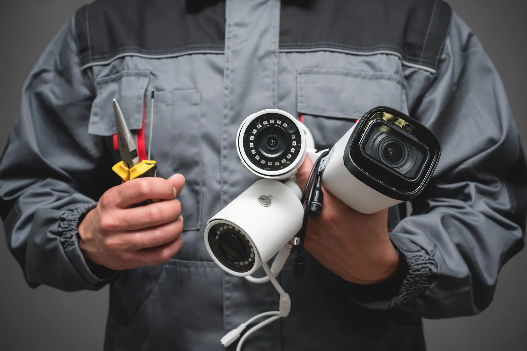 Một người đàn ông đang cầm các camera an ninh, tượng trưng cho việc Smart TV thu thập dữ liệu giám sát