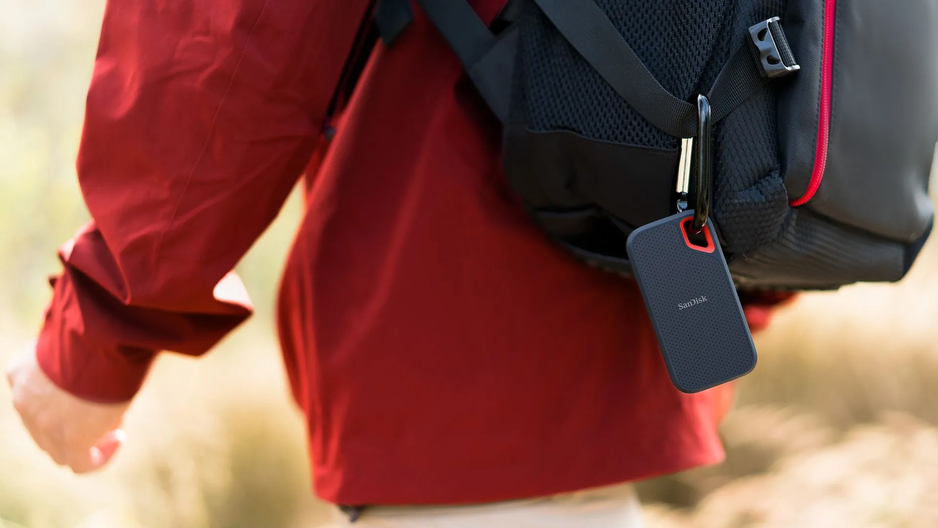 Một người đàn ông đang đạp xe với SanDisk Extreme Portable SSD 8TB được gắn vào ba lô, thể hiện tính di động và bền bỉ