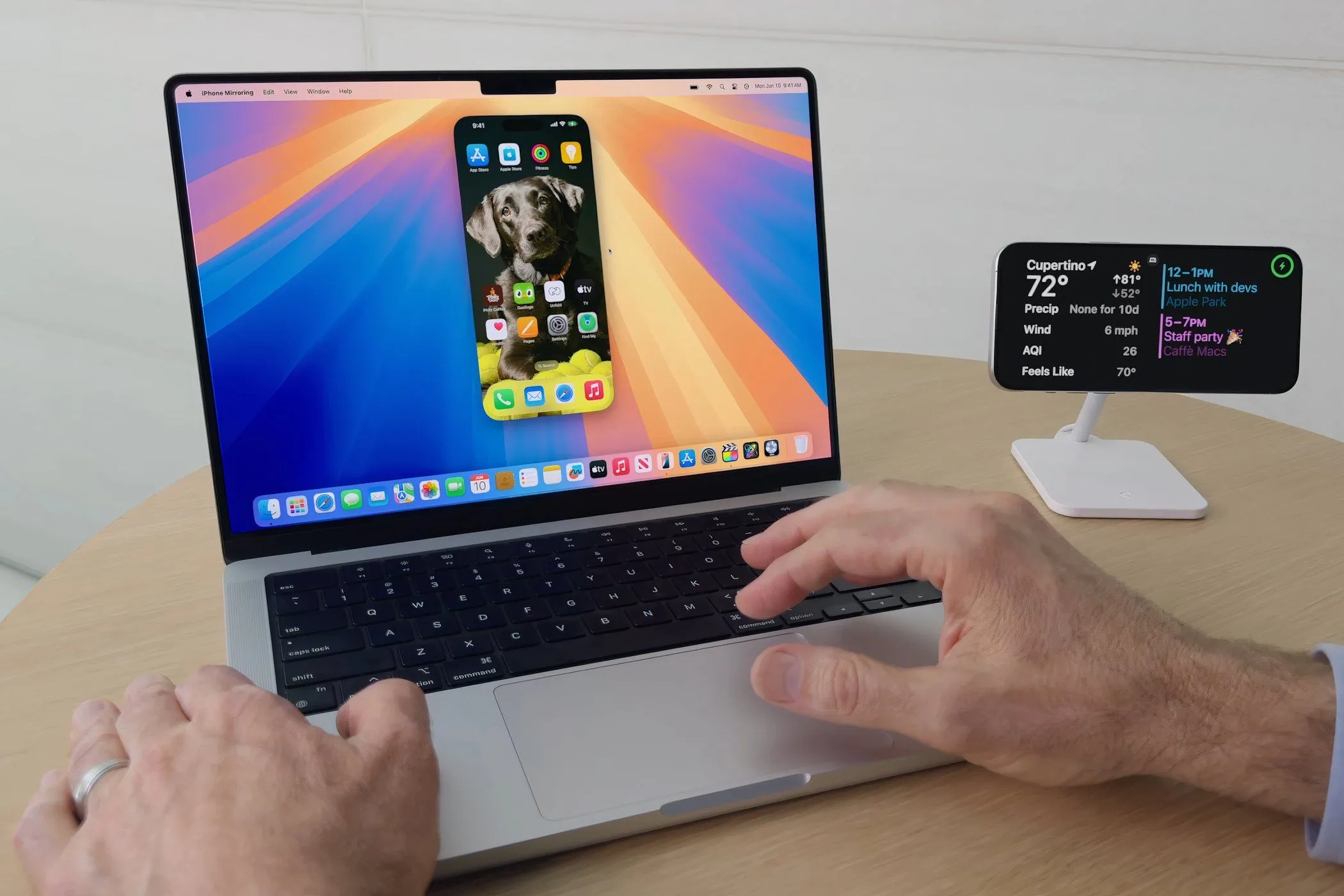 Một người đàn ông đang sử dụng MacBook Pro chạy macOS Sequoia với tính năng iPhone Mirroring đang hoạt động.