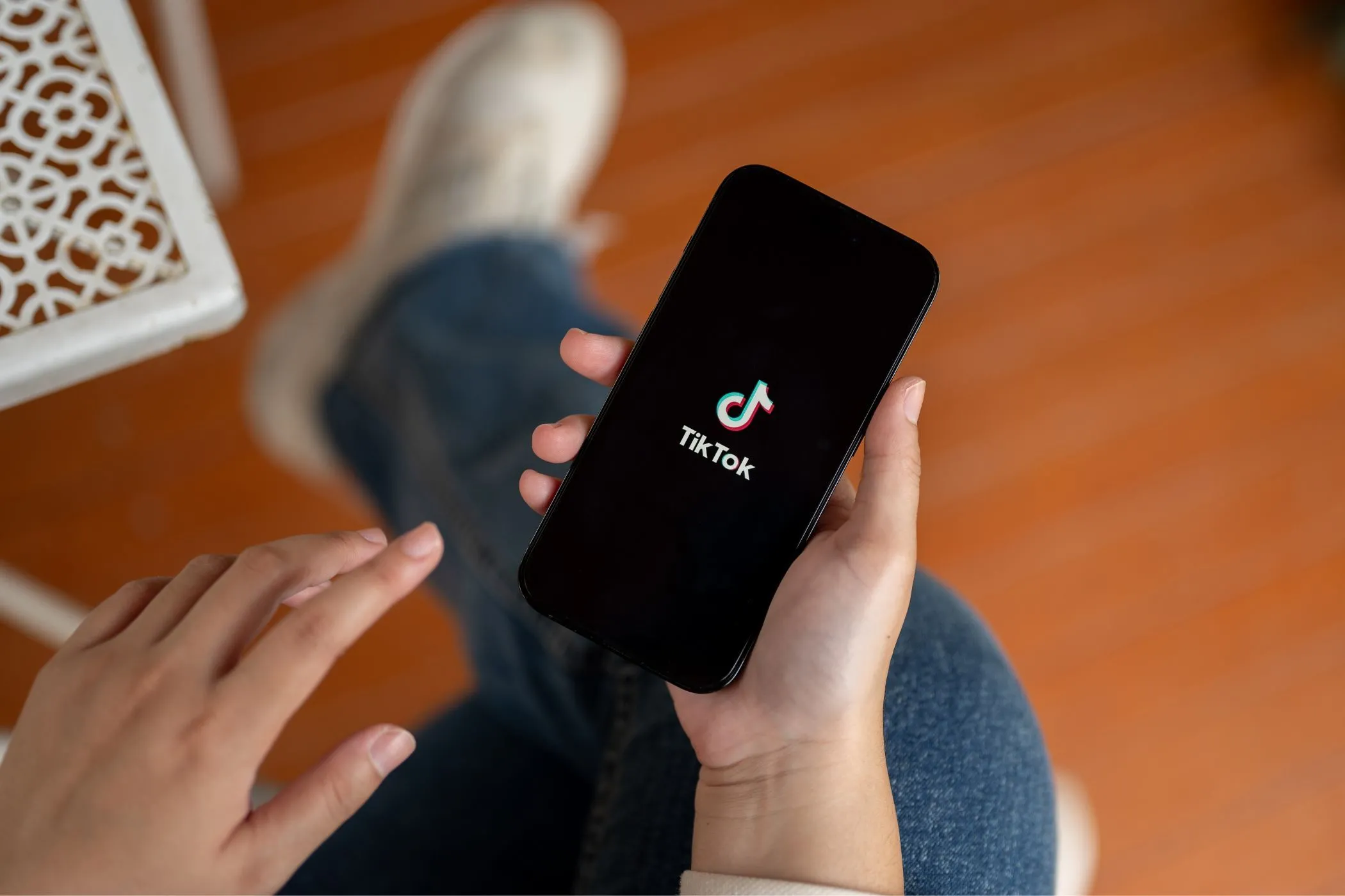 Một người đang cầm điện thoại thông minh hiển thị ứng dụng TikTok trên màn hình