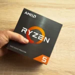 Người đàn ông cầm hộp vi xử lý AMD Ryzen 5, biểu tượng cho sức mạnh chip laptop