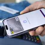 Người đàn ông sử dụng Apple Pay trên iPhone để thanh toán tại cửa hàng