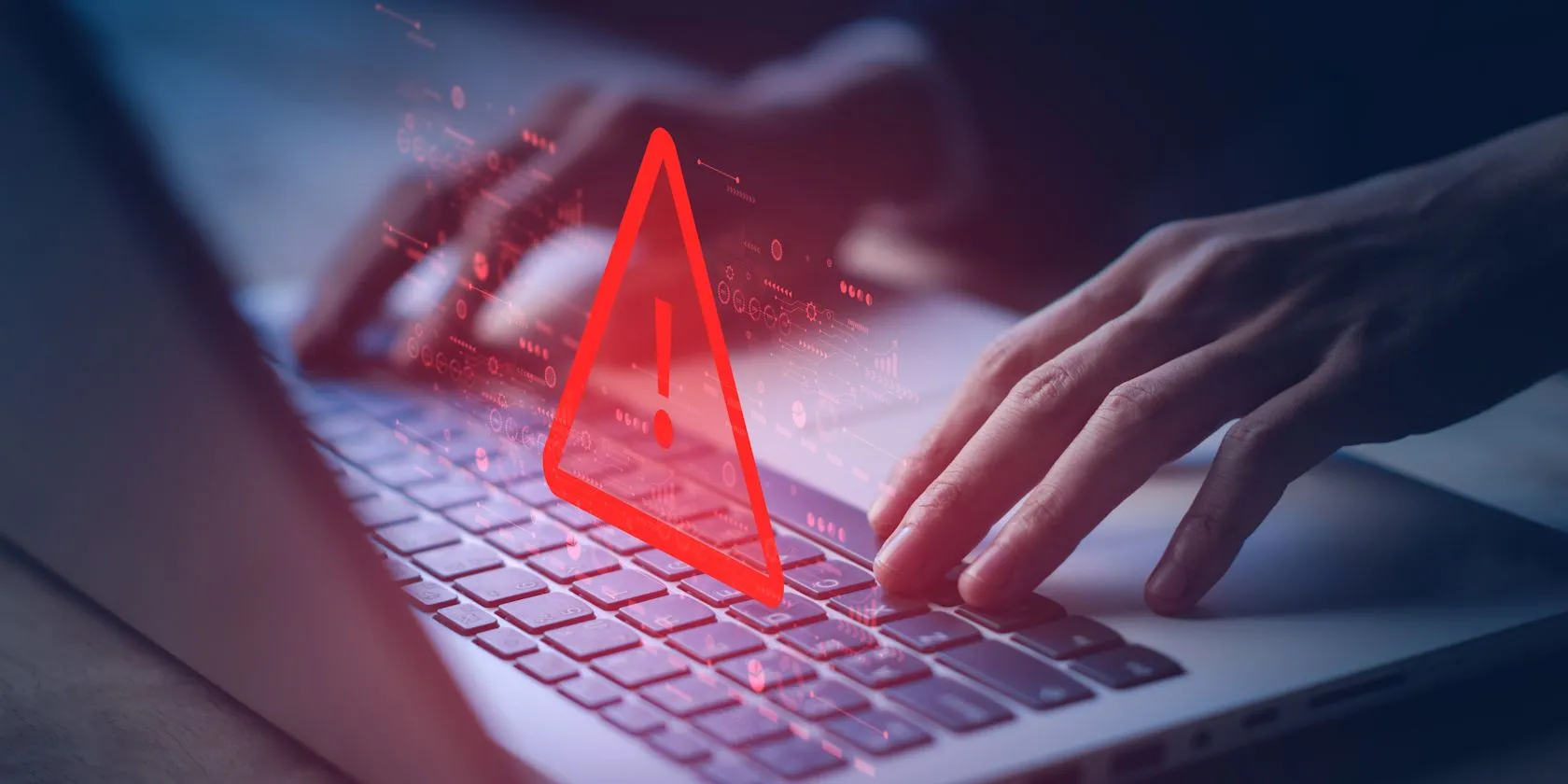 Người đang sử dụng laptop với cảnh báo hệ thống bị tấn công