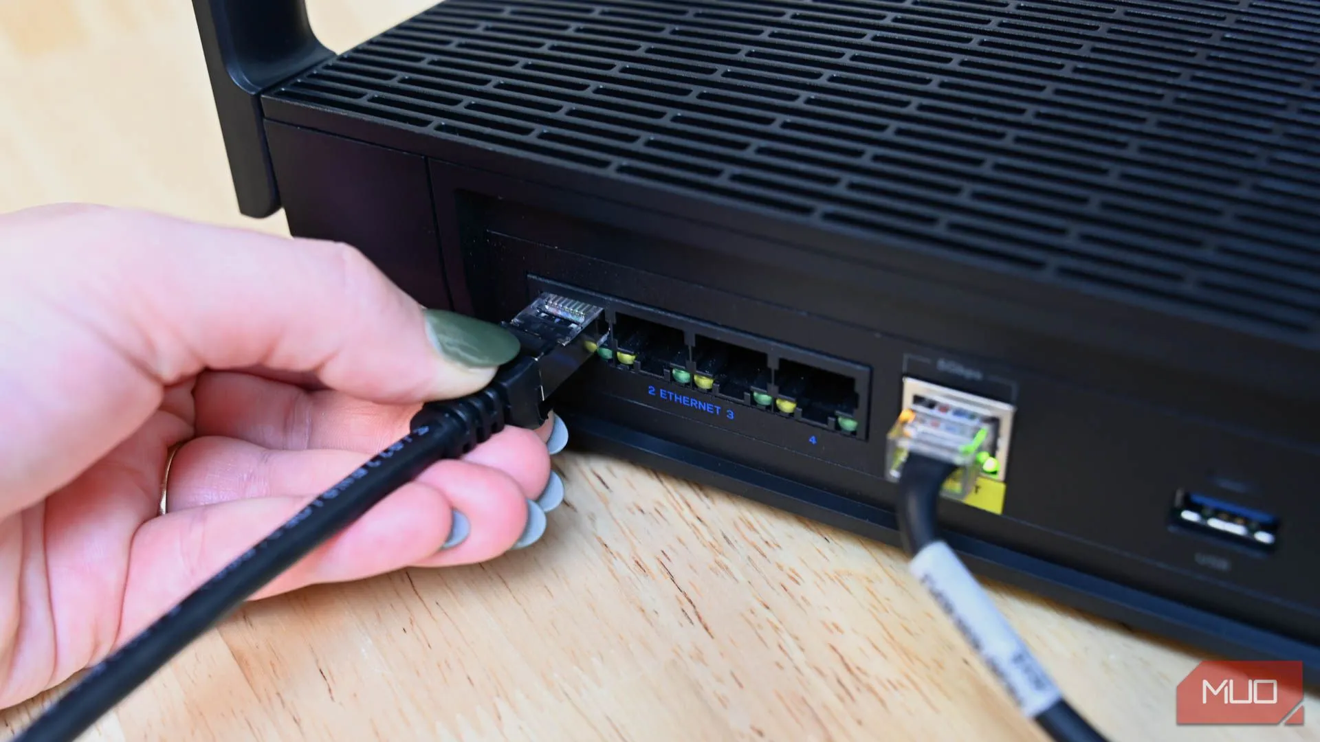 Người dùng cắm cáp Ethernet vào router du lịch, biểu tượng cho việc ưu tiên kết nối mạng có dây