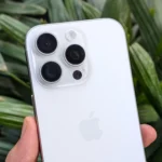 Người dùng cầm iPhone 16 Pro màu trắng với cụm camera sau nổi bật