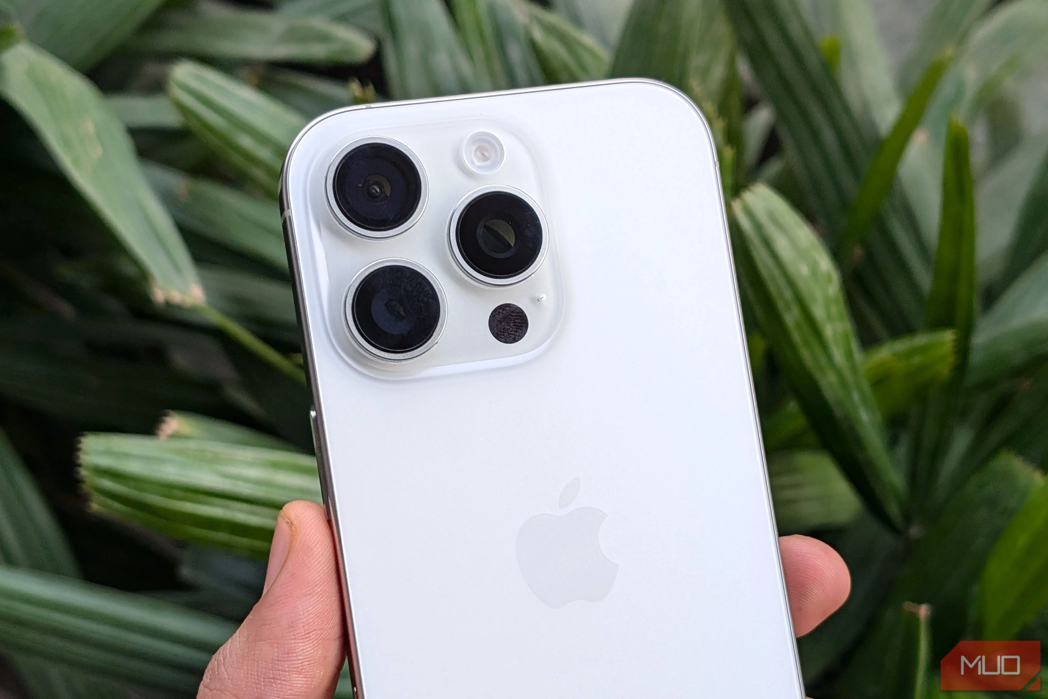 Người dùng cầm iPhone 16 Pro màu trắng với cụm camera sau nổi bật
