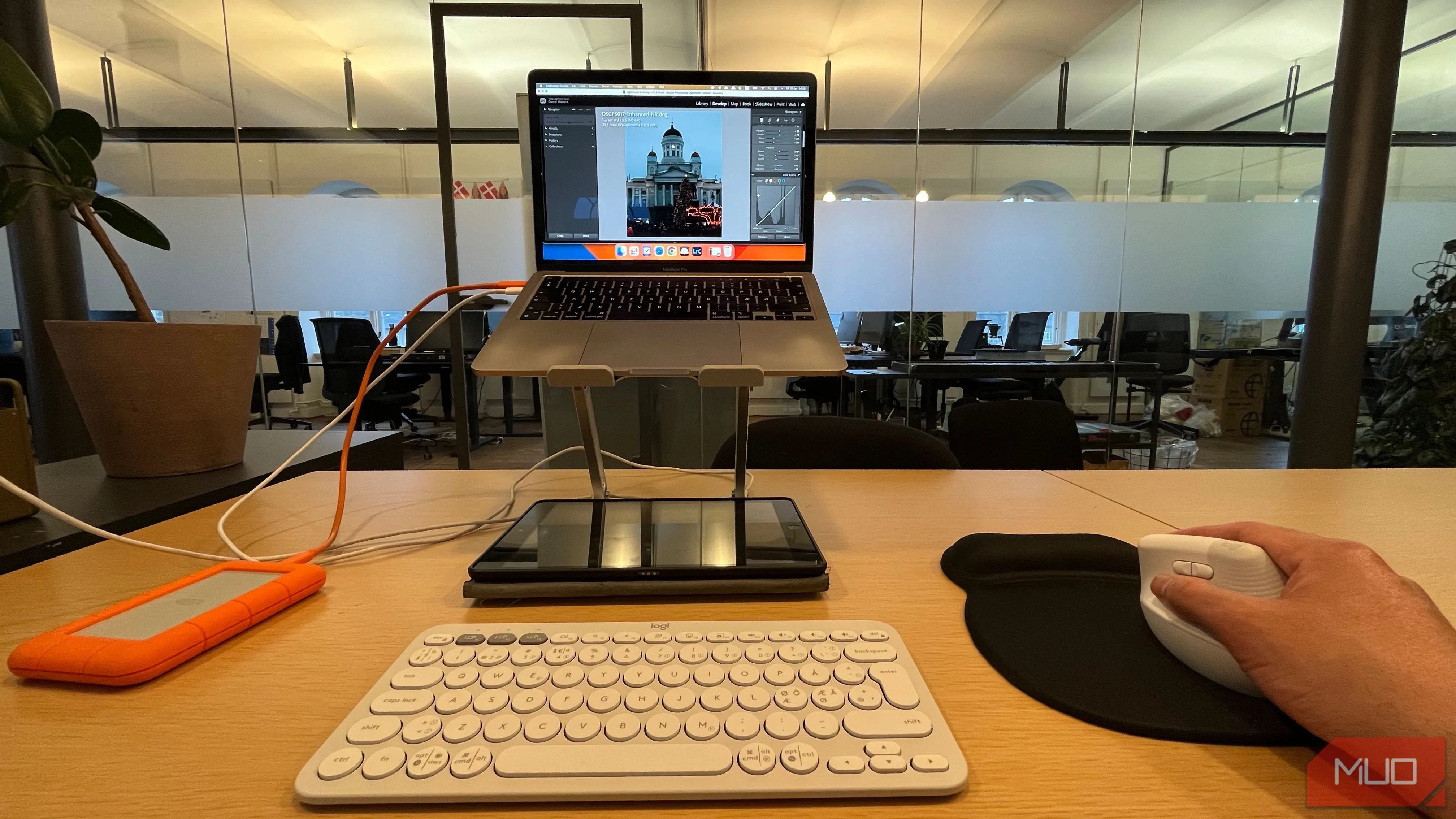 Người dùng chỉnh sửa ảnh trên laptop bằng chuột không dây, minh họa sự tiện lợi khi xử lý tác vụ đồ họa chuyên nghiệp