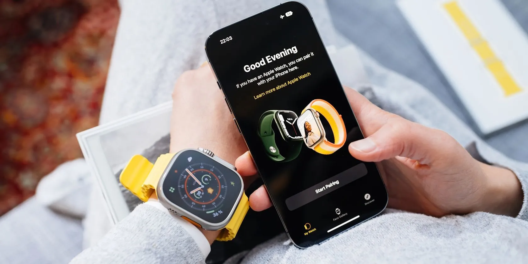 Người dùng đang ghép nối đồng hồ thông minh Apple Watch Ultra với iPhone để cài đặt