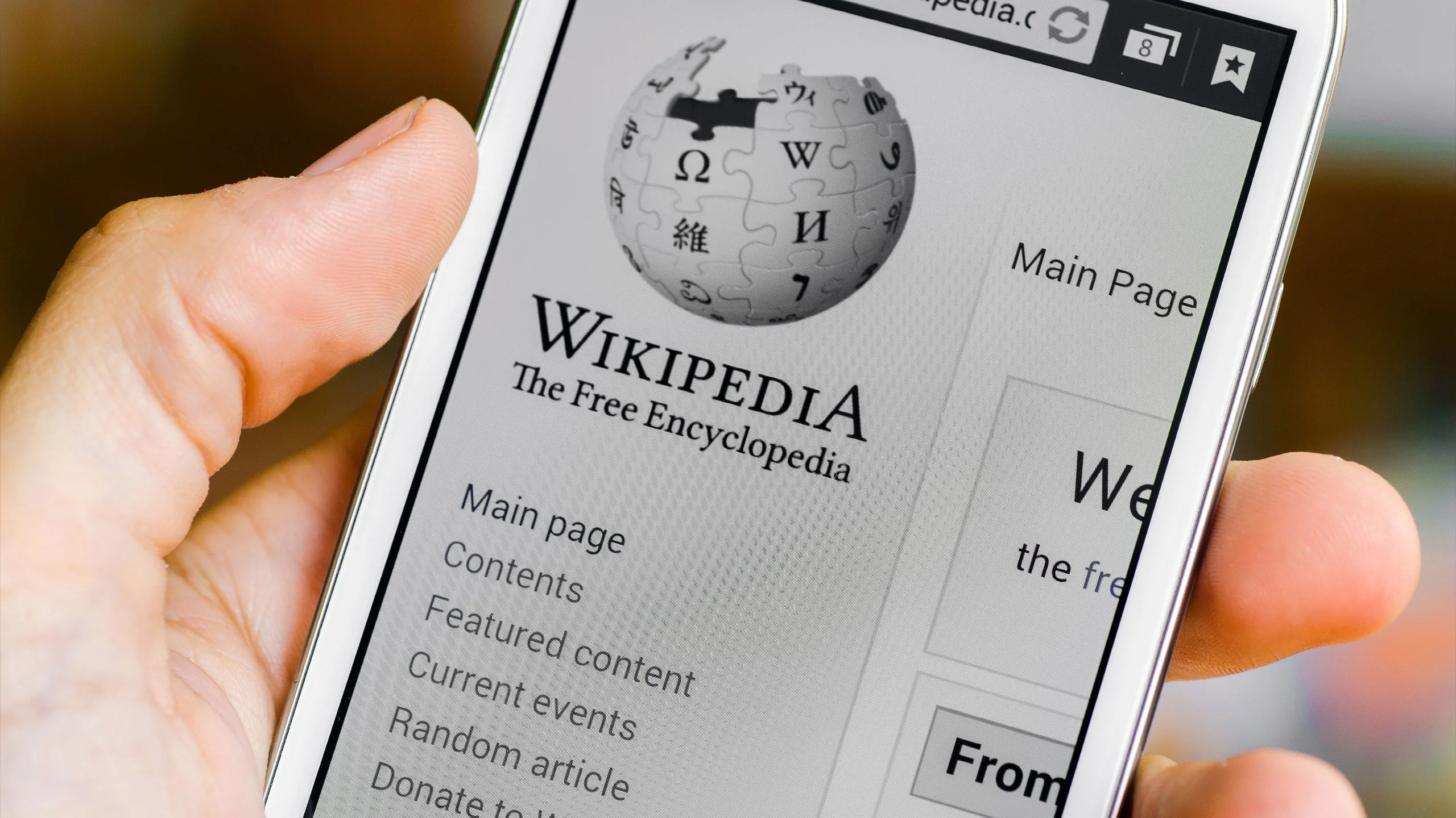 Người dùng truy cập Wikipedia trên điện thoại để nghiên cứu thông tin, thể hiện vai trò trung tâm của Wikipedia và tầm nhìn về AI hỗ trợ biên tập viên.