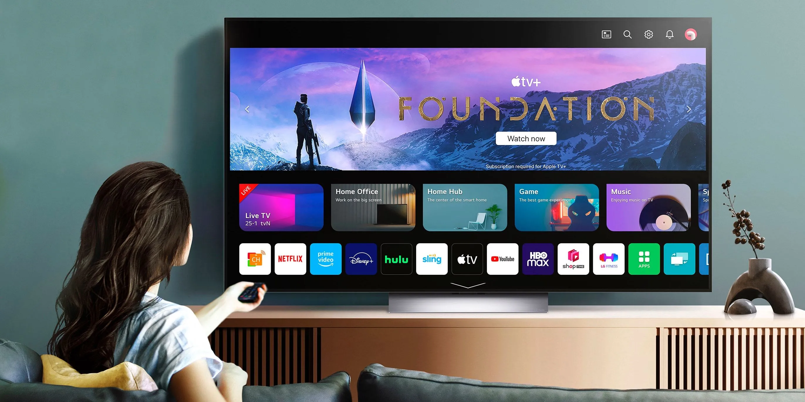 Người phụ nữ xem chương trình Foundation trên TV LG OLED Evo, minh họa độ tương phản sâu và màu sắc sống động của công nghệ OLED trong môi trường gia đình.