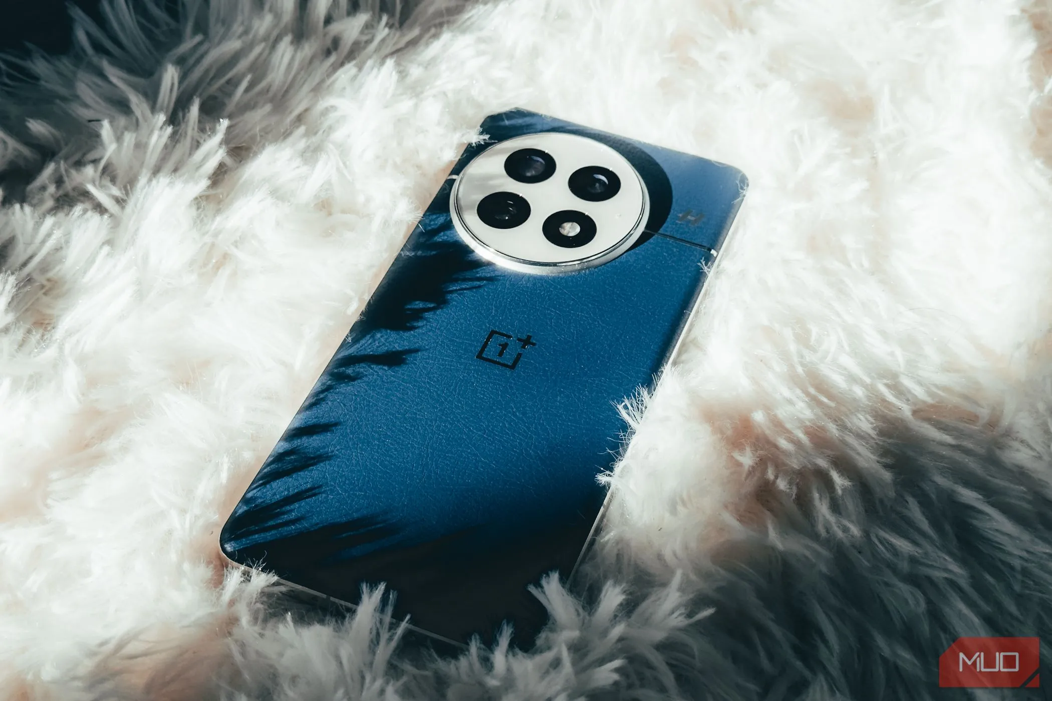 OnePlus 13 đặt trên thảm lông màu trắng, thể hiện thiết kế tinh tế