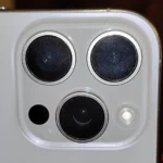 Ống kính camera iPhone bị bẩn với nhiều vết dầu mỡ nhìn rõ dưới ánh đèn