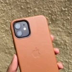 Ốp lưng iPhone 12 bằng da màu nâu vàng trên tay, thể hiện vẻ ngoài cao cấp và bền bỉ của chất liệu da thật