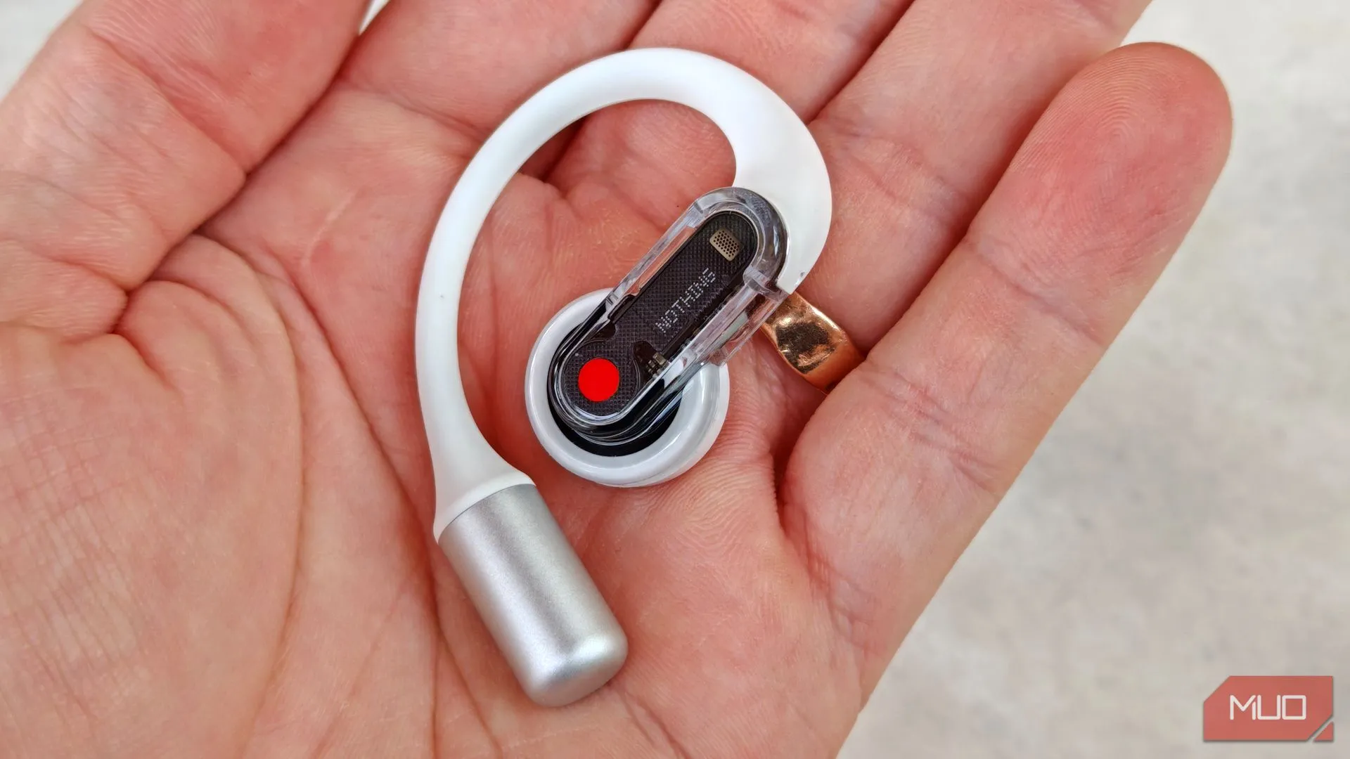 Tai nghe Nothing Ear (open) bên phải được cầm trên tay, cho thấy cơ chế điều khiển bóp