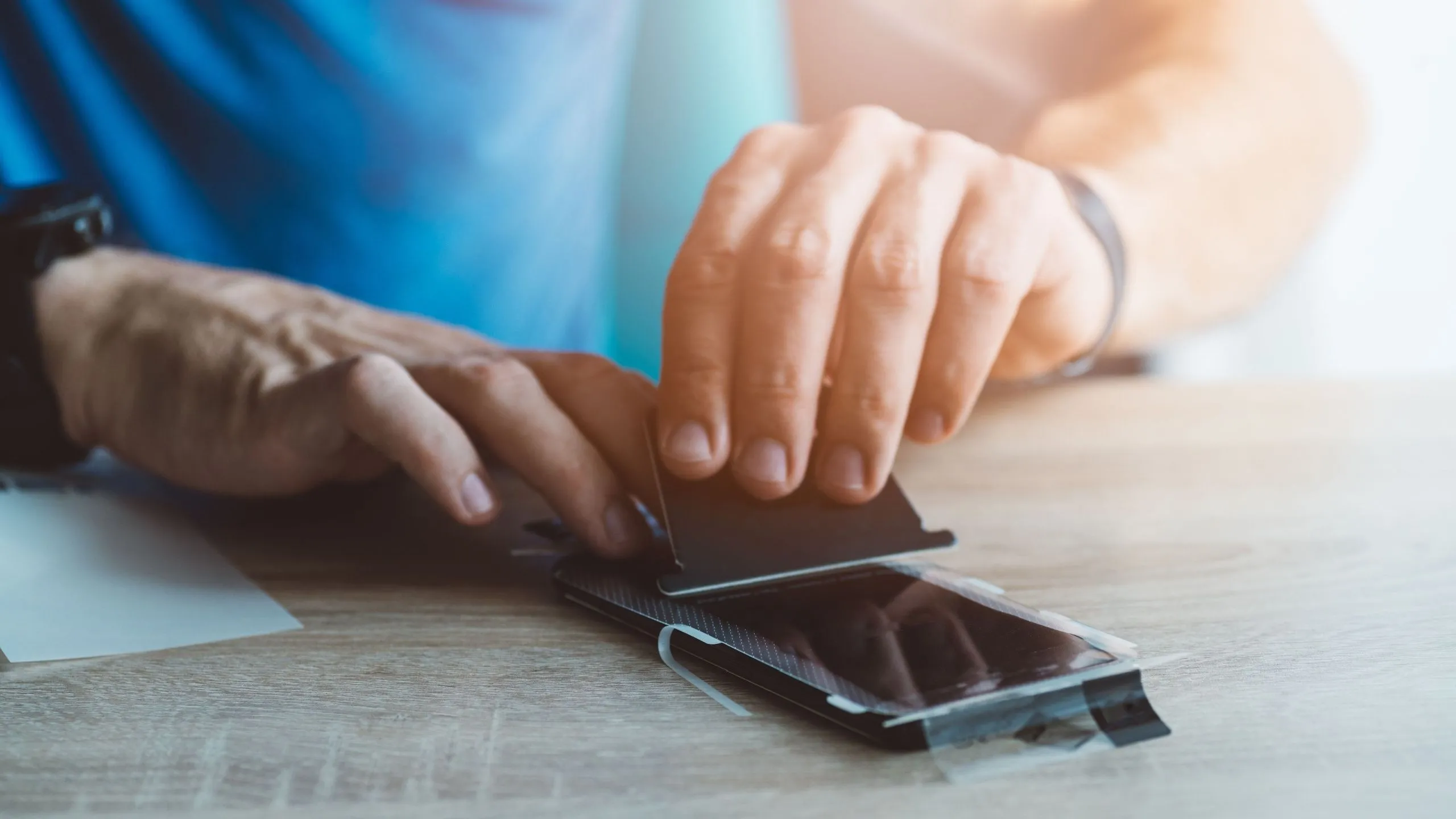 Tấm dán màn hình kháng khuẩn đang được dán lên điện thoại iPhone.