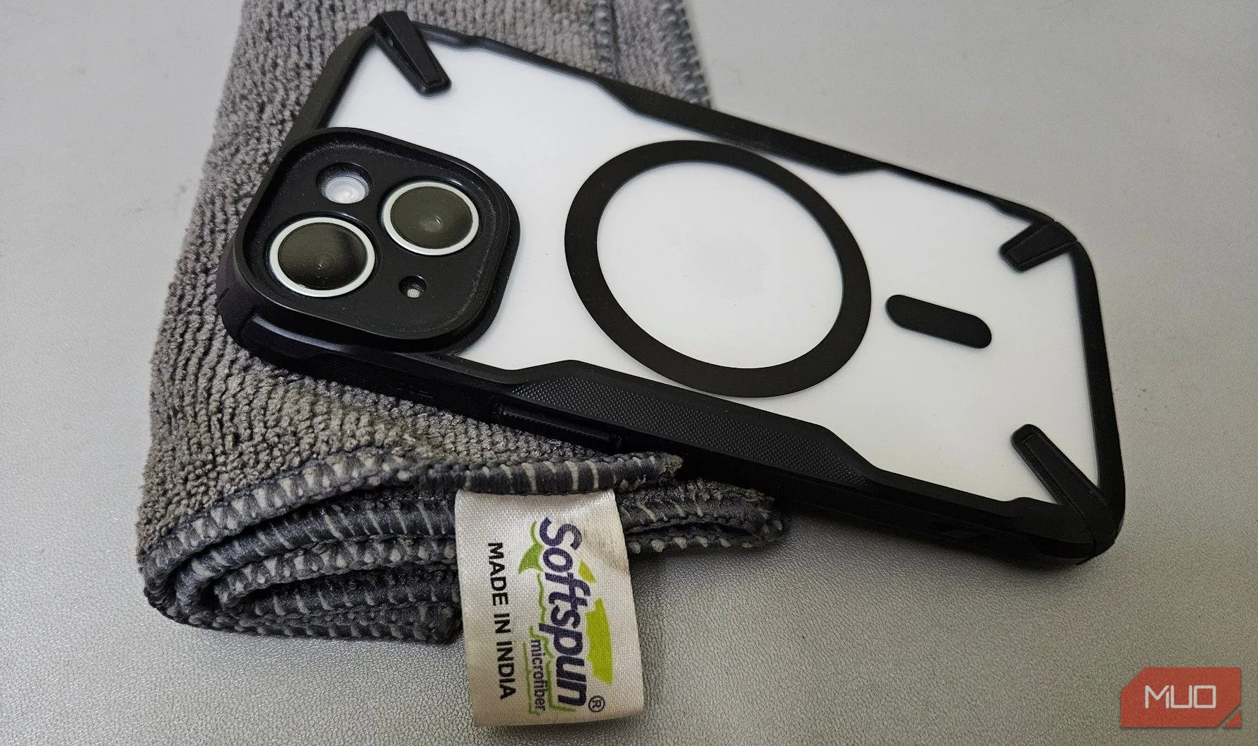 Tay người dùng lau sạch ống kính camera điện thoại bằng khăn vải mềm microfiber trước khi chụp ảnh đêm, đảm bảo chất lượng hình ảnh