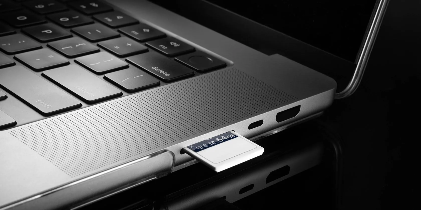 Thẻ SD đang được cắm vào khe cắm thẻ nhớ trên laptop, biểu thị khả năng mở rộng bộ nhớ linh hoạt