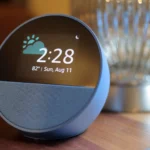 Thiết bị Amazon Echo Spot màu xanh đặt trên bề mặt gỗ, tượng trưng cho việc dữ liệu Alexa được xử lý trên đám mây