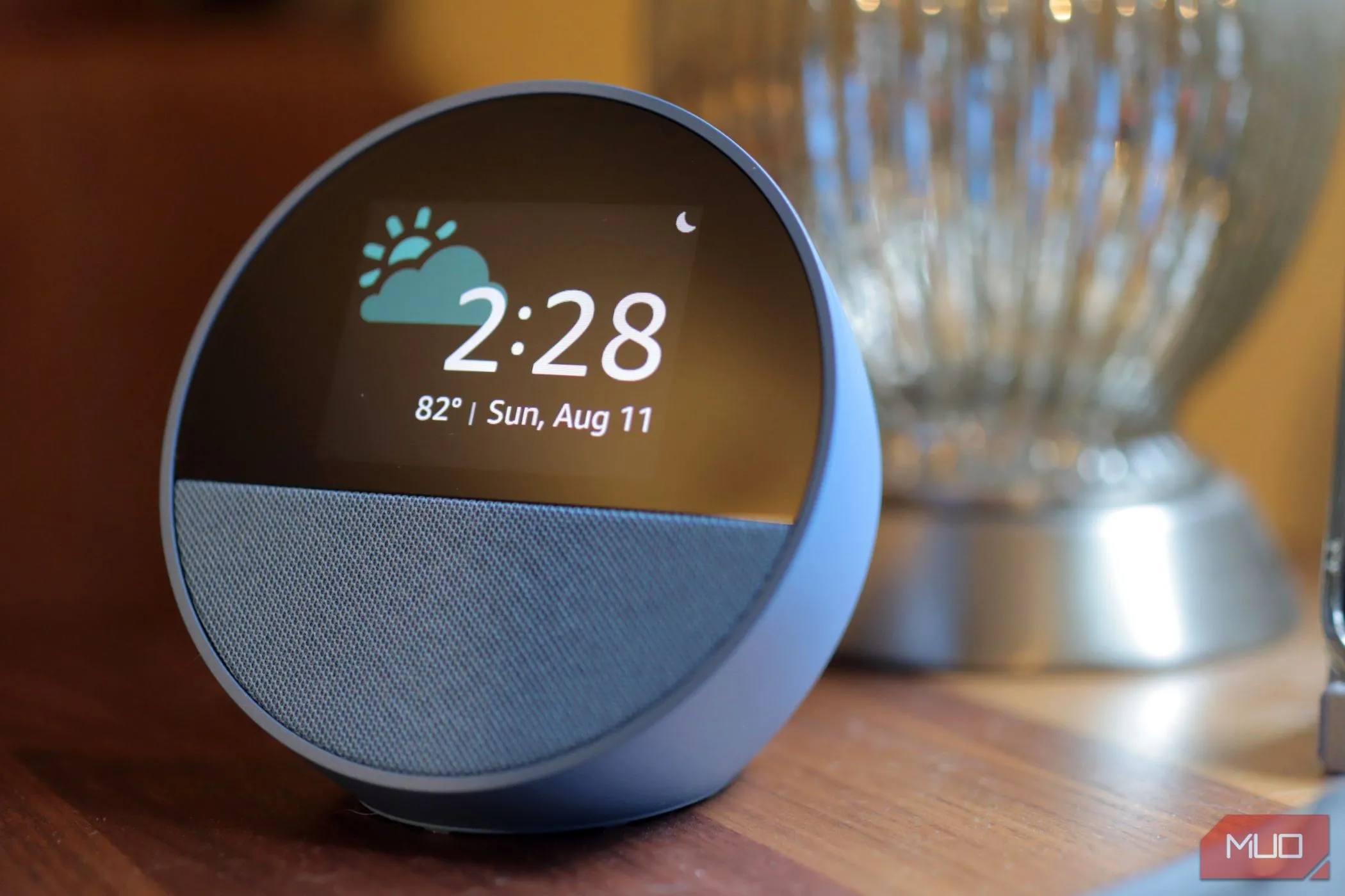 Thiết bị Amazon Echo Spot màu xanh đặt trên bề mặt gỗ, tượng trưng cho việc dữ liệu Alexa được xử lý trên đám mây